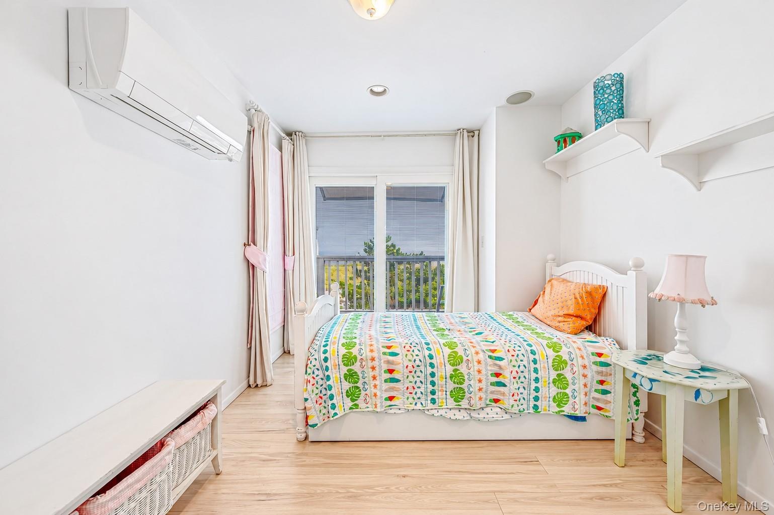 Guest bedroom w/ en suite wood-finish flooring, sliding glass door