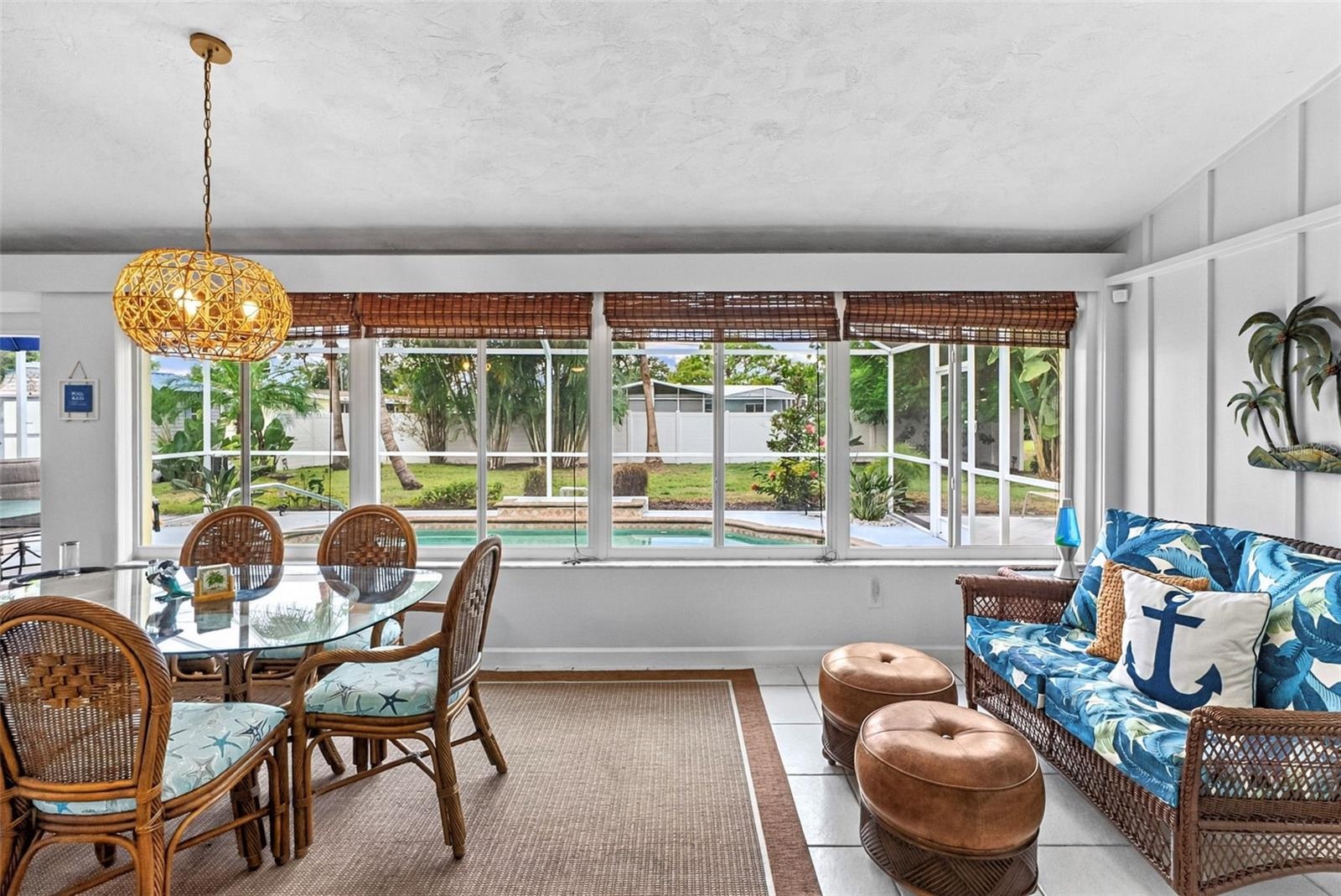 Florida room with dining and sitting areas overlooking the pool.