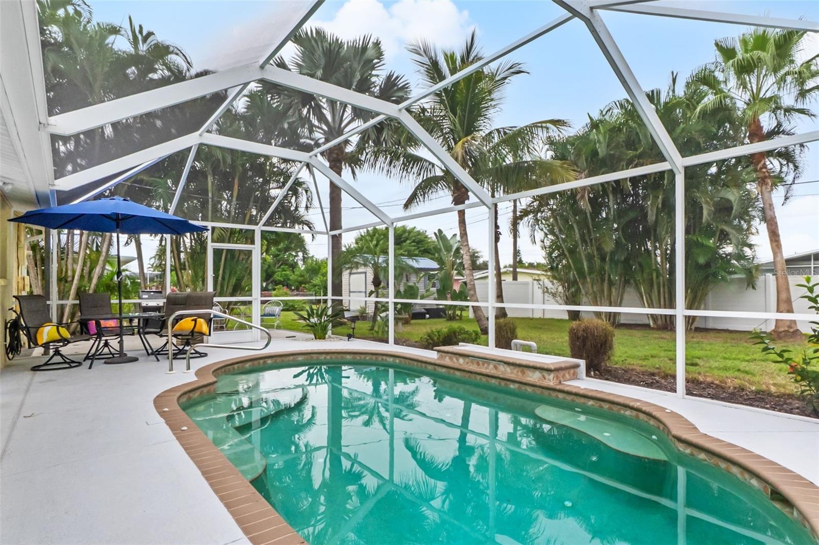 Alternate view of the pool with poolside seating and outdoor dining area.