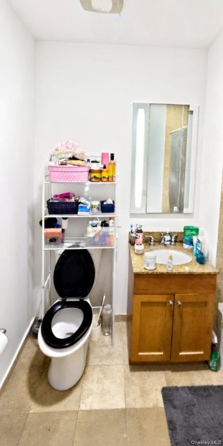Built-in vanity with a granite countertop, undermount sink, and wood-finish cabinetry