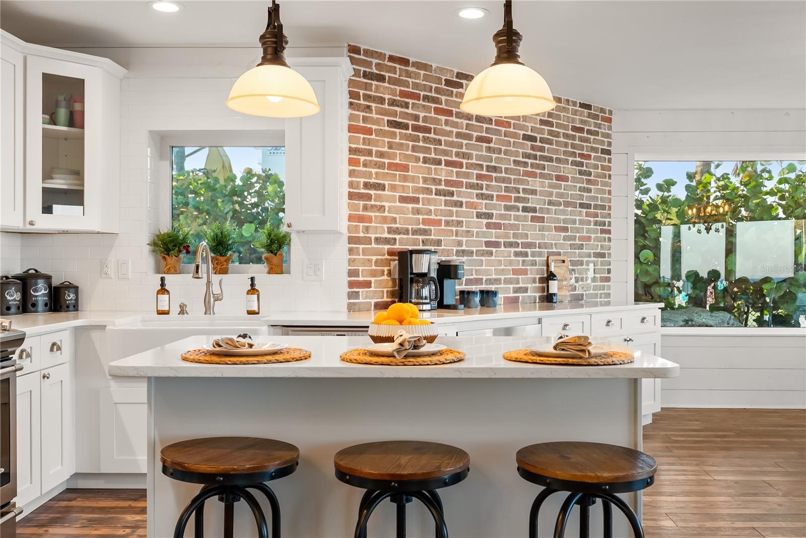 Spacious eat-in kitchen with stainless steel appliances, quartz countertops, breakfast bar seating, and beautiful ocean views—an inviting setting for 
