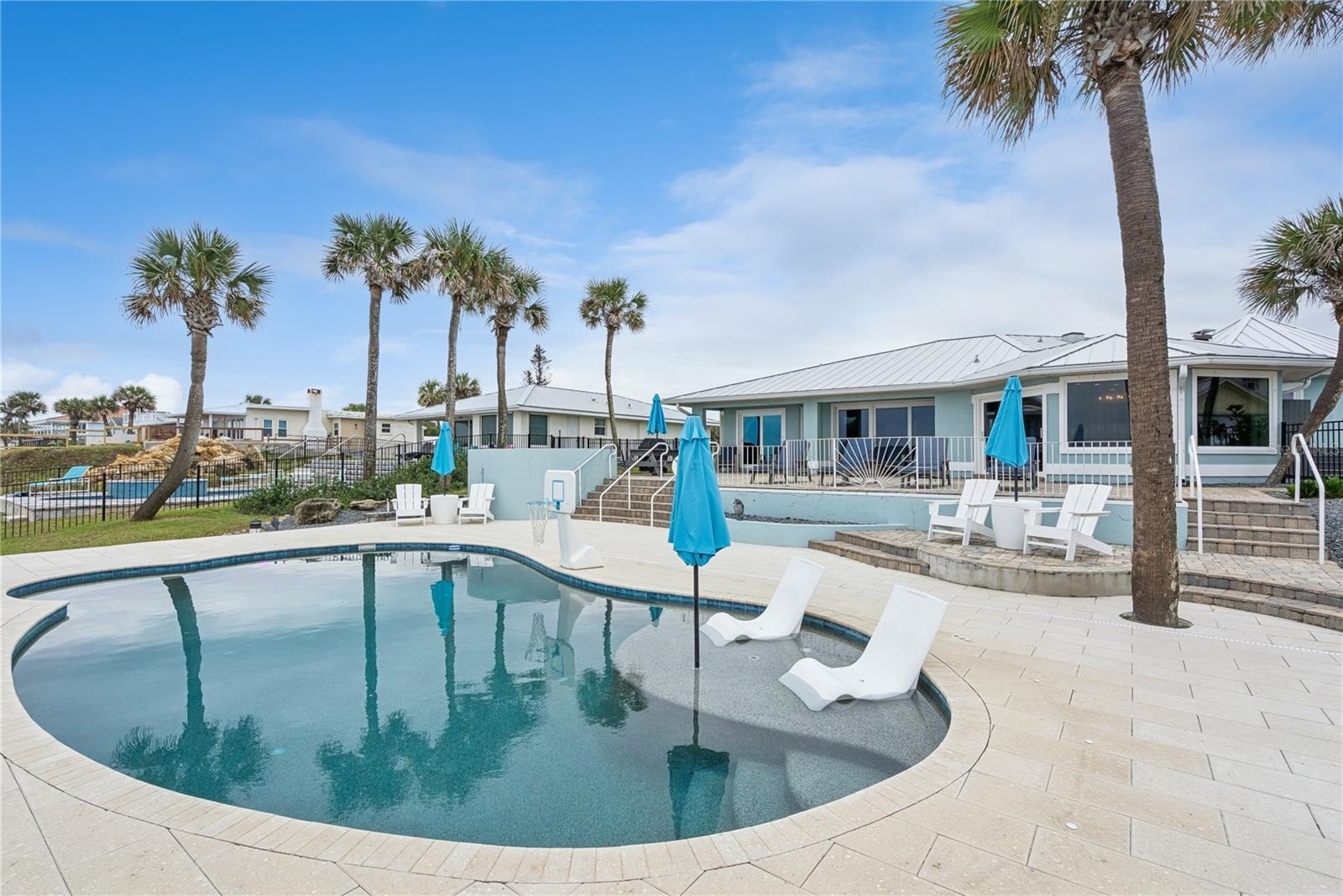 New oceanfront pool installed in 2024, featuring heating, a sun shelf, bubblers, and a 7-foot-deep end, with expansive patio space and panoramic Atlan