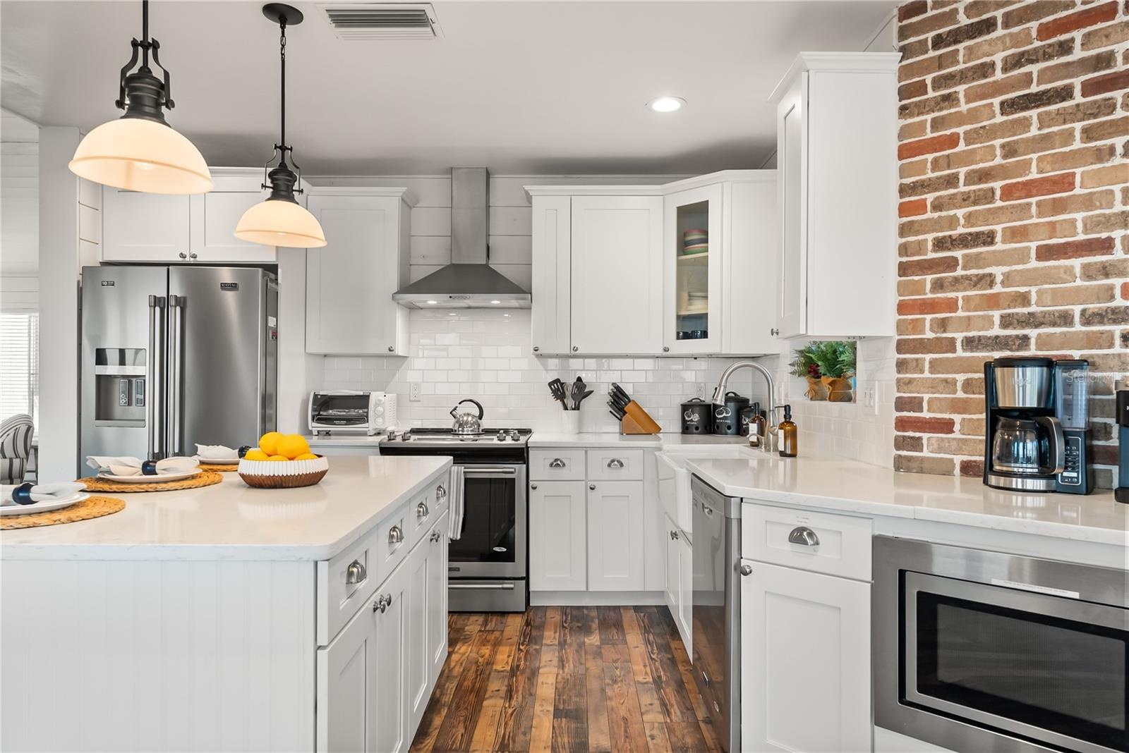 Spacious eat-in kitchen with stainless steel appliances, quartz countertops, breakfast bar seating, and beautiful ocean views—an inviting setting for 