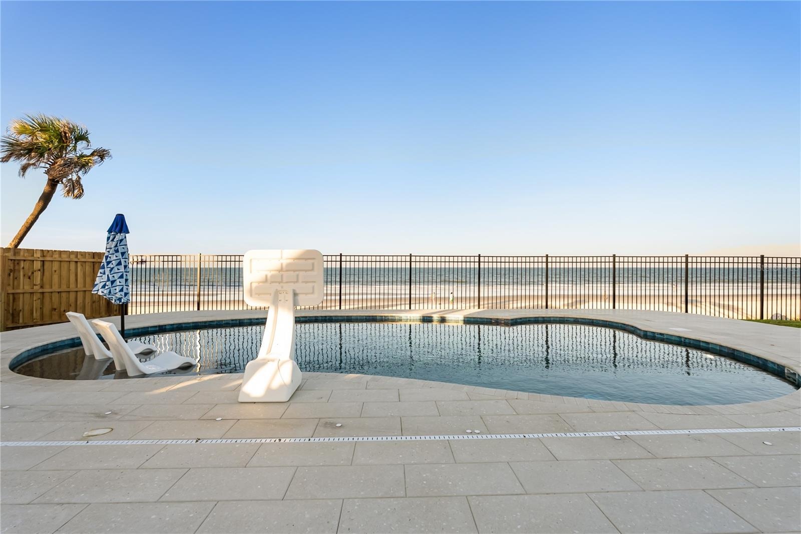 new poolNew oceanfront pool installed in 2024, featuring heating, a sun shelf, bubblers, and a 7-foot-deep end, with expansive patio space and panoram
