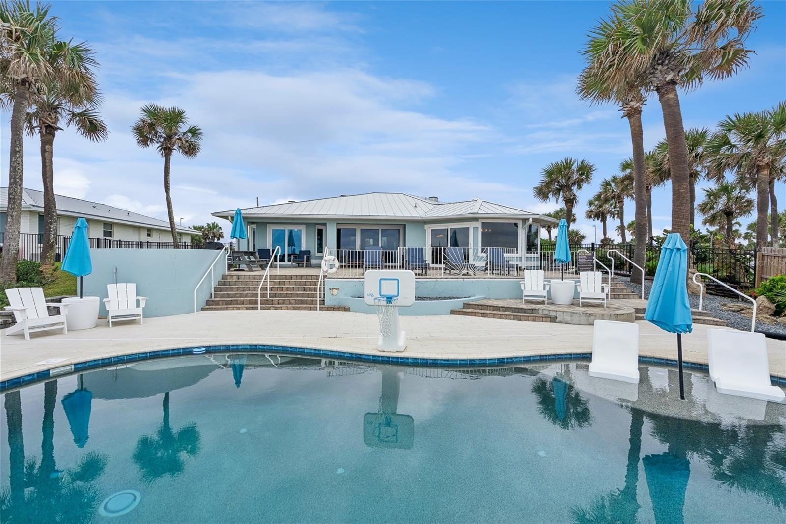 New oceanfront pool installed in 2024, featuring heating, a sun shelf, bubblers, and a 7-foot-deep end, with expansive patio space and panoramic Atlan