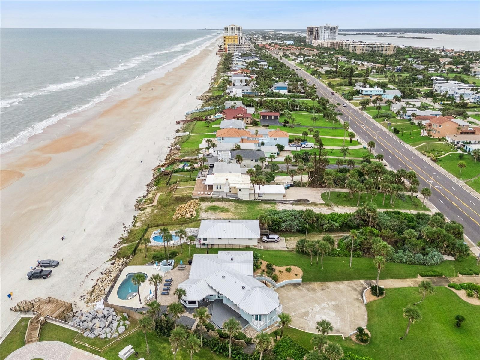 Set on over three-quarters of an acre with approximately 85 feet of ocean frontage, this property offers a generous setback from the road, ample drive