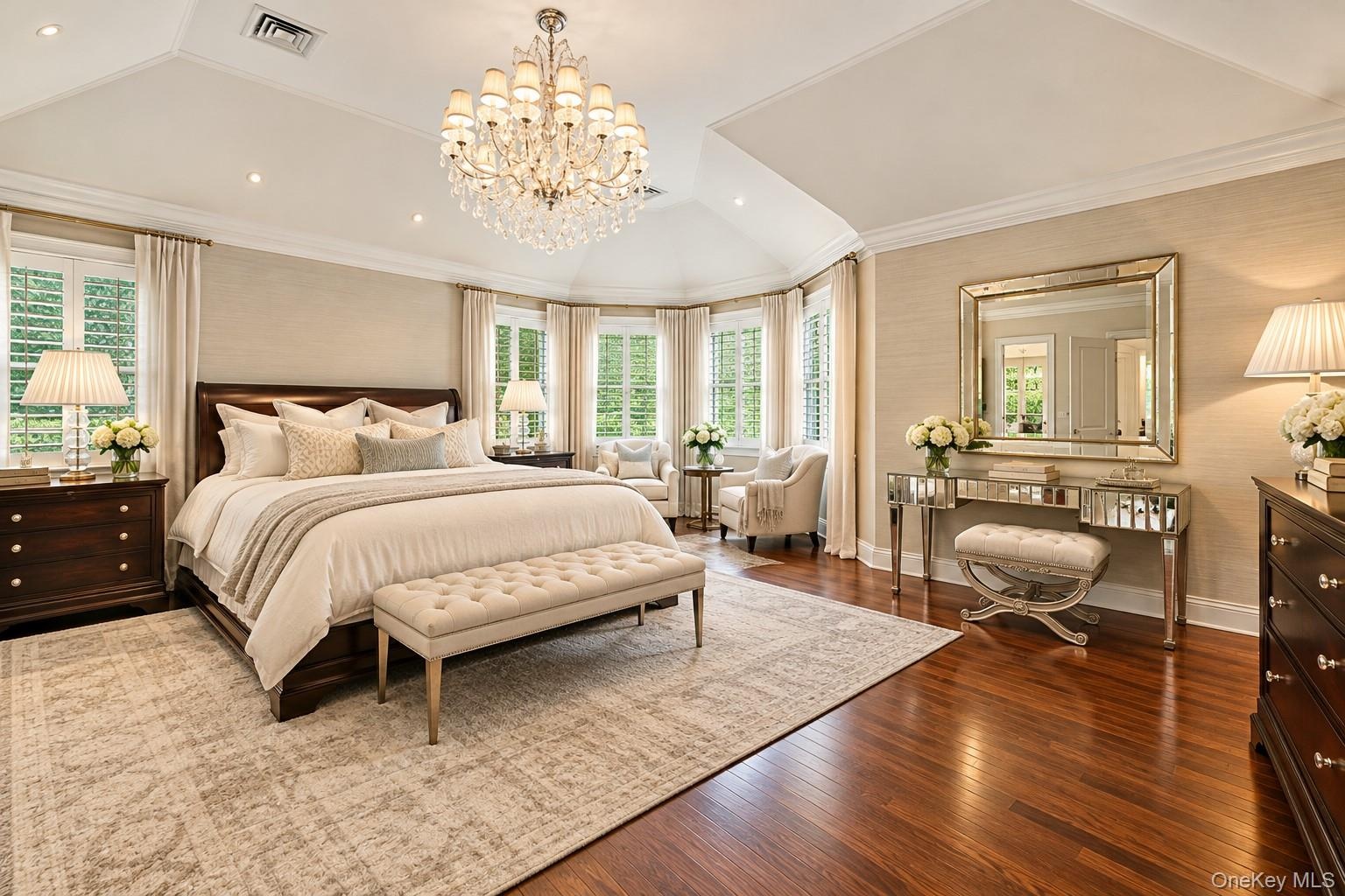 Tray ceiling with a crystal chandelier, wood-finish flooring, and a bay window