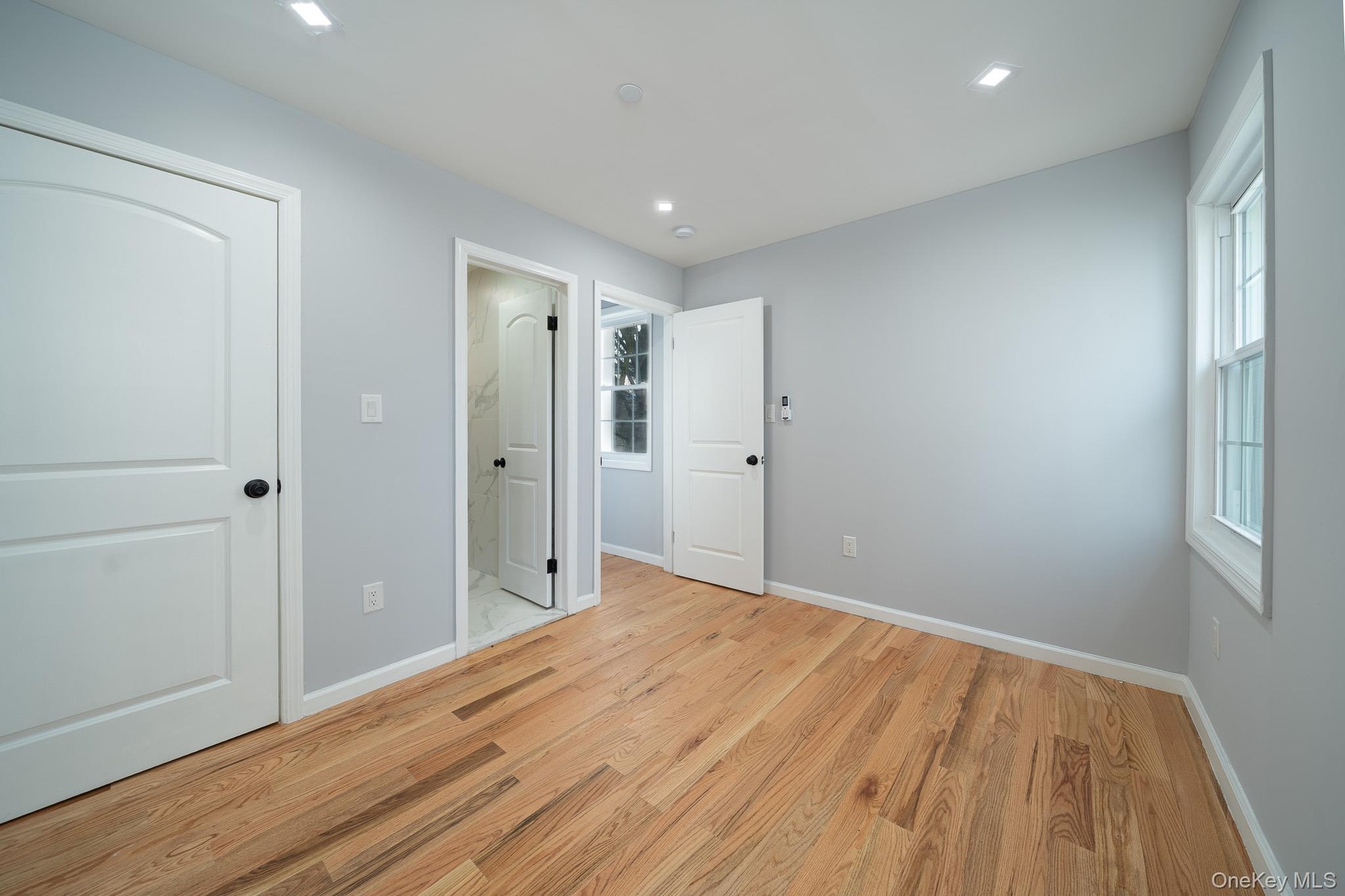 Unfurnished bedroom with light wood finished floors, ensuite bath, and recessed lighting