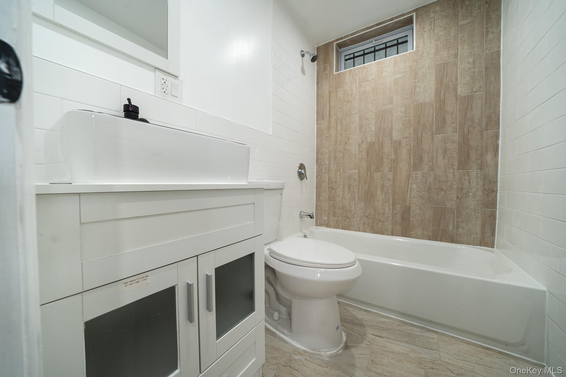 Bathroom featuring vanity, bathtub / shower combination, and tile walls
