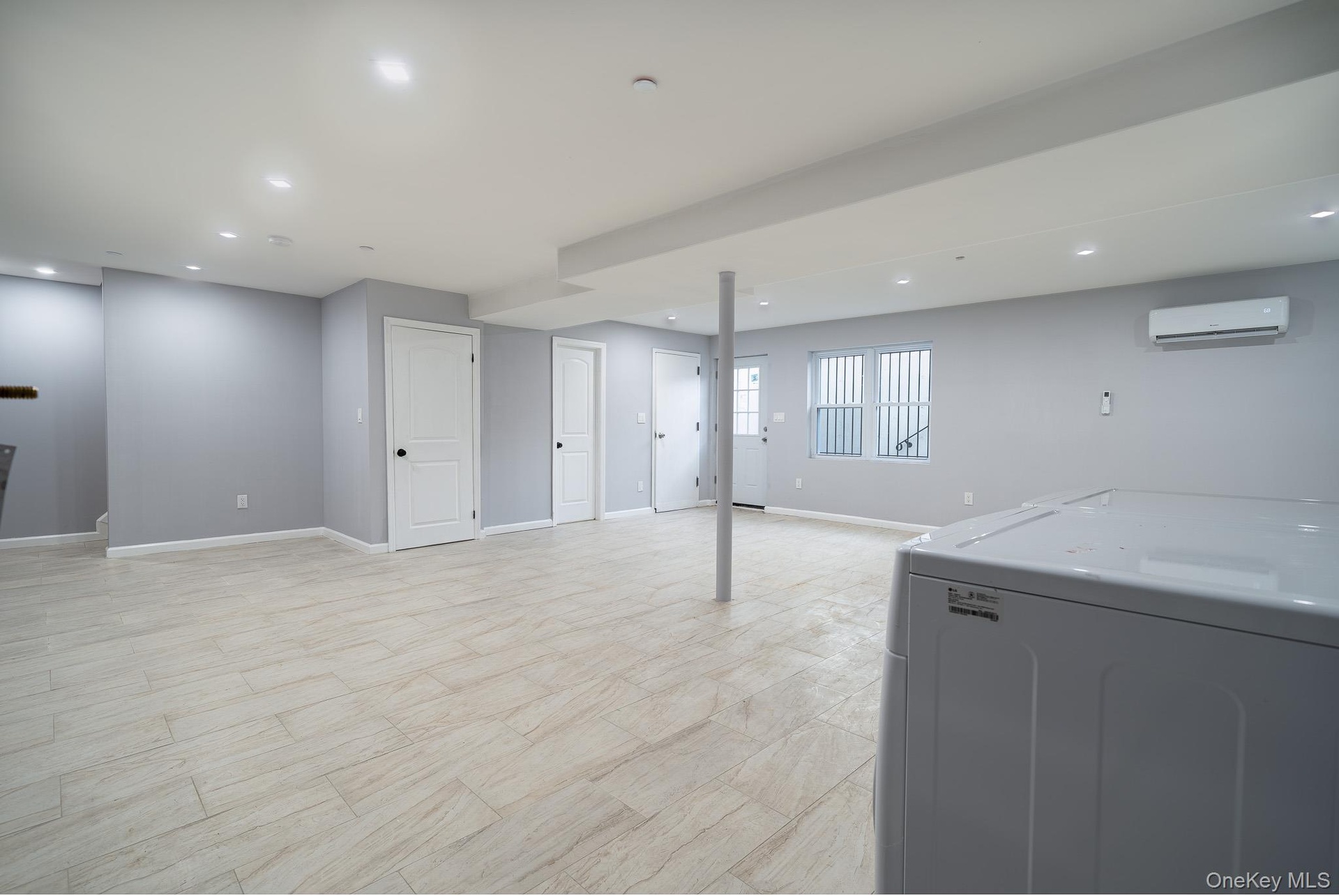 Basement featuring washer / dryer, recessed lighting, and a wall mounted air conditioner