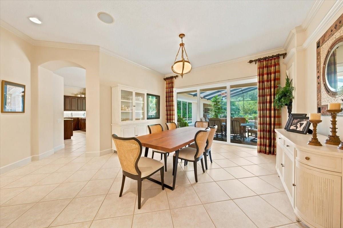Large sliders frame views of the screened lanai, pool, and lush backyard.