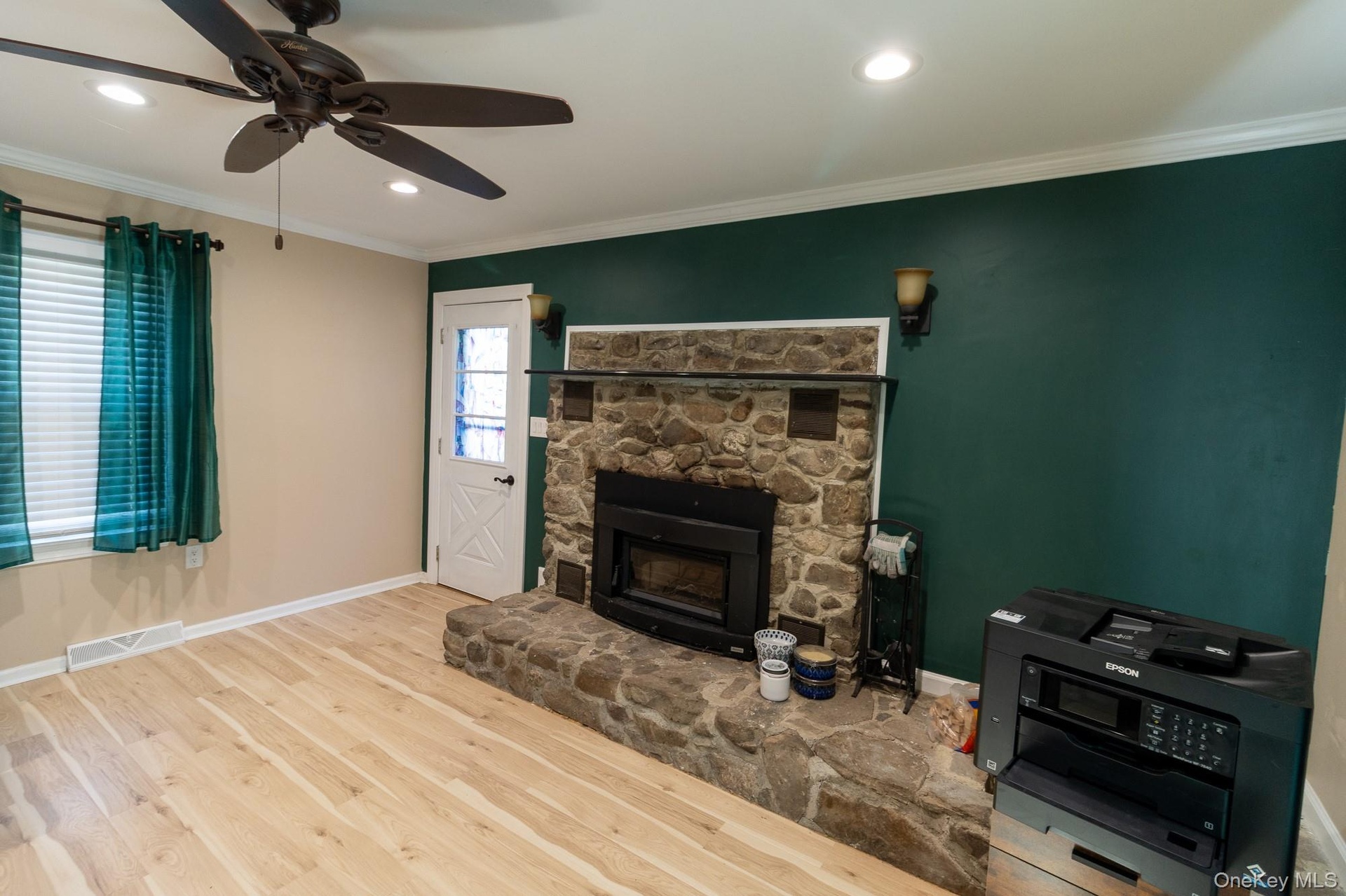This versatile interior space with a stone fireplace is suitable for a variety of uses.