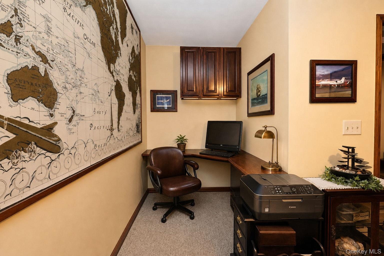 L shaped office  with corner configuration, recessed lighting, upper wood-finish cabinetry and door to rear deck