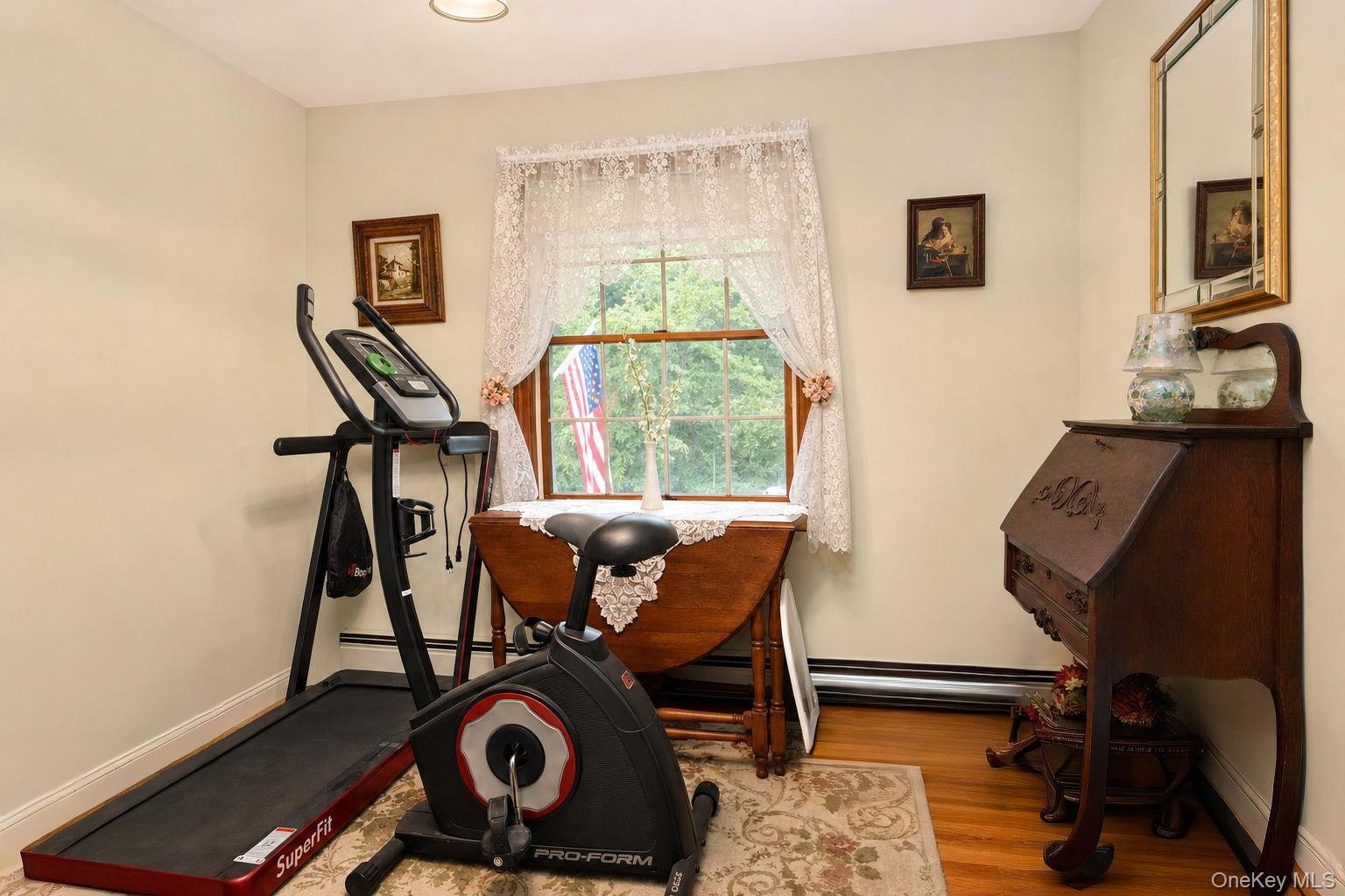 Hardwood flooring, painted walls, window with trim, and recessed ceiling light