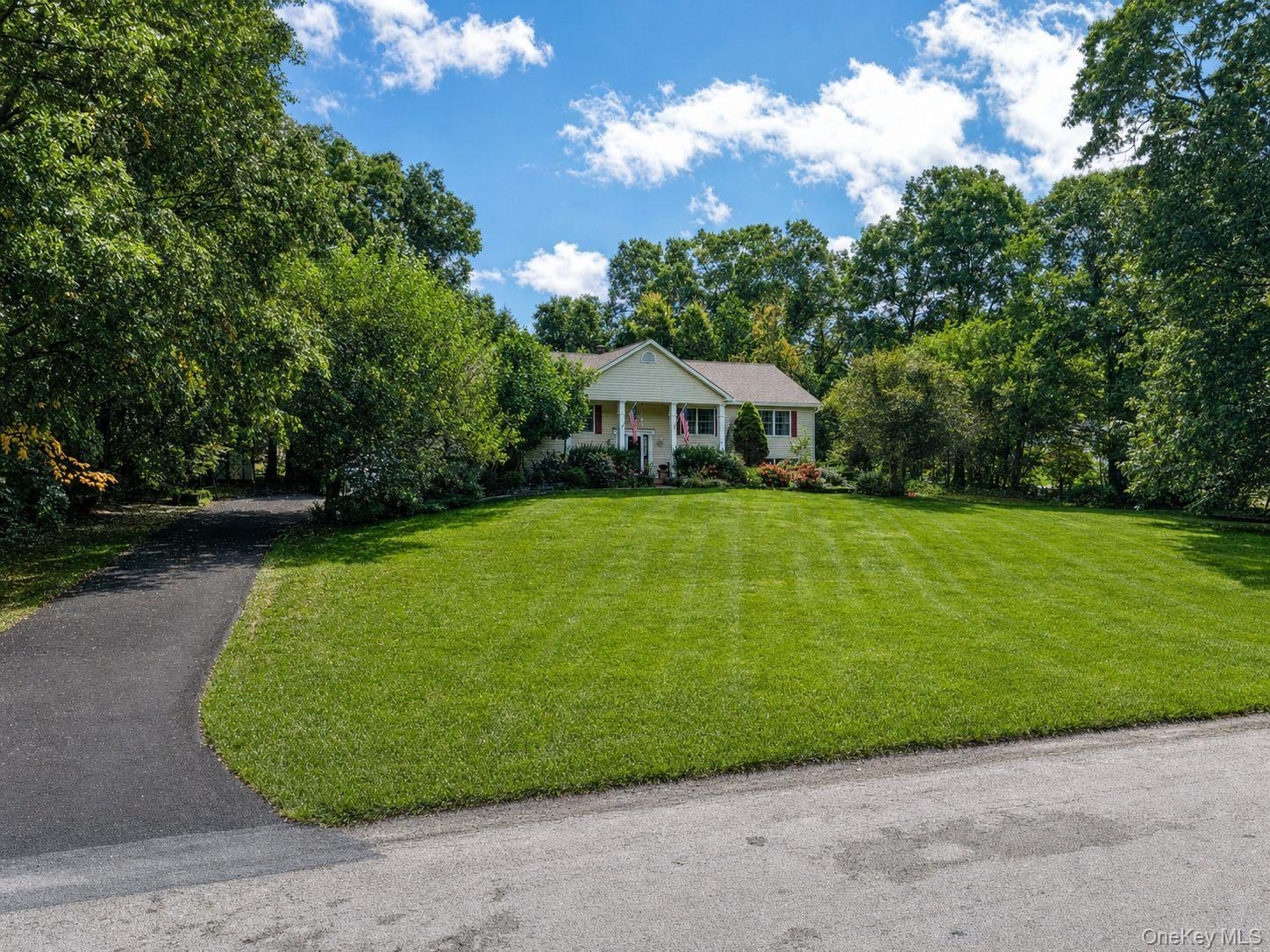 Front of the home with manicured lawn and new paved driveway