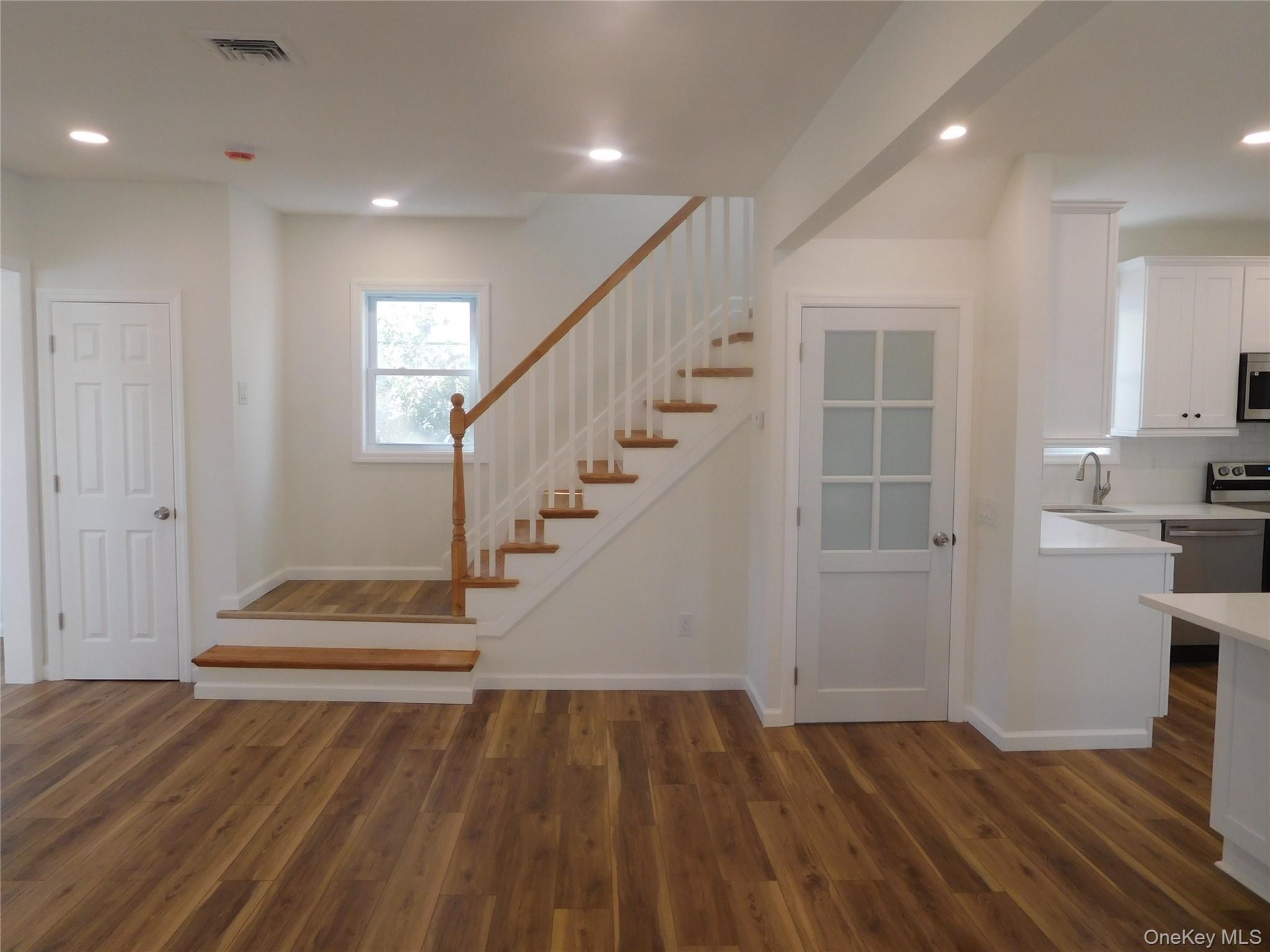 LIVINGROOM WITH FROSTED DOOR LEADING TO FULL BASEMENT