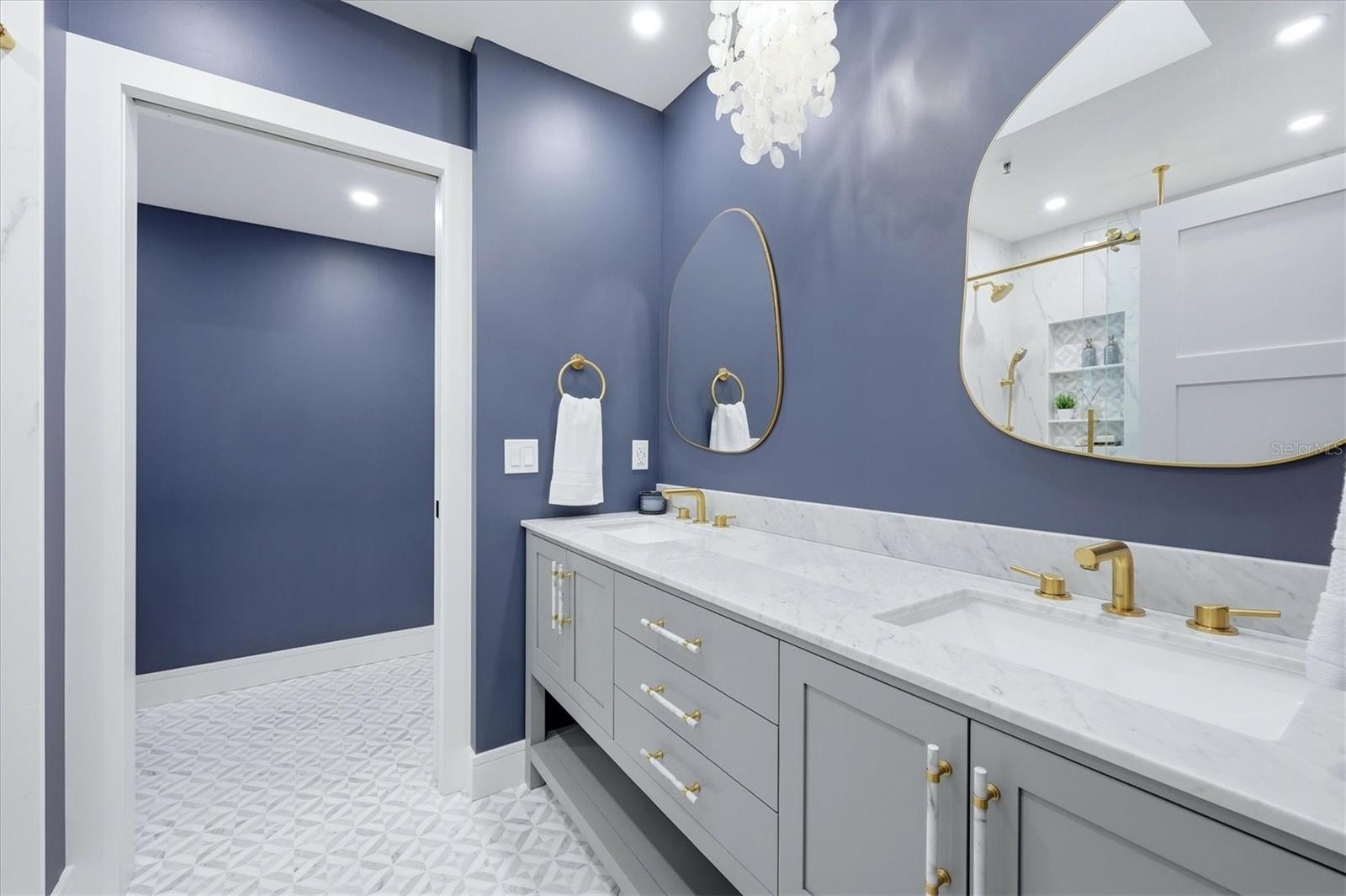 Primary Bathroom with Double Sinks and Carerra Marble vanity top, water closet with linen storage