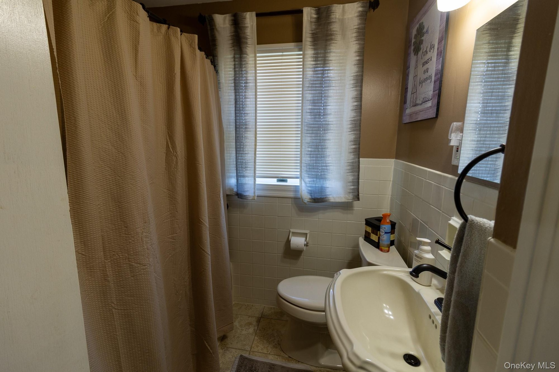 The bathroom features natural light and a timeless vanity.