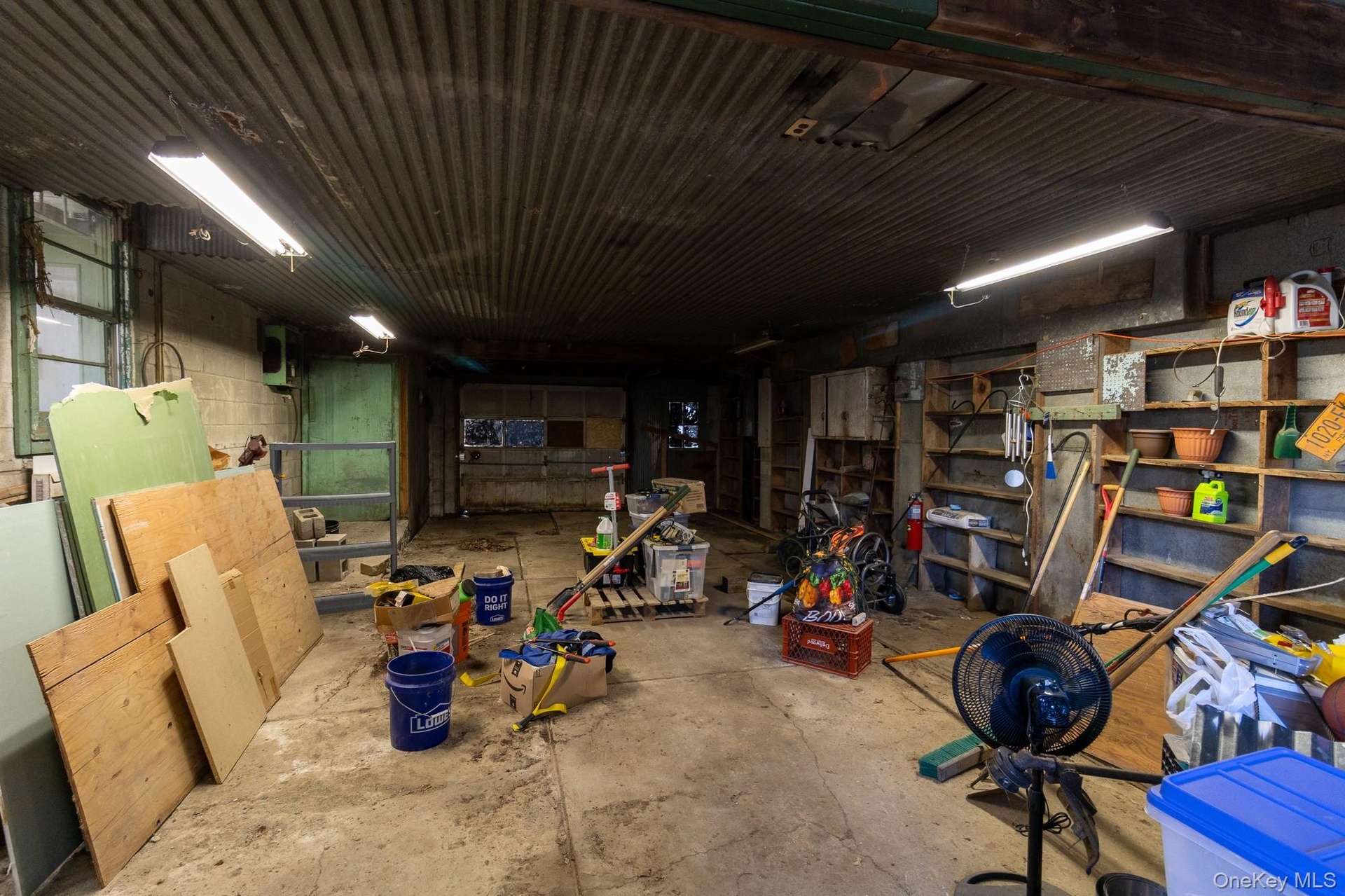 Enclosed work area within the barn featuring shelving, overhead lighting and ample workspace.