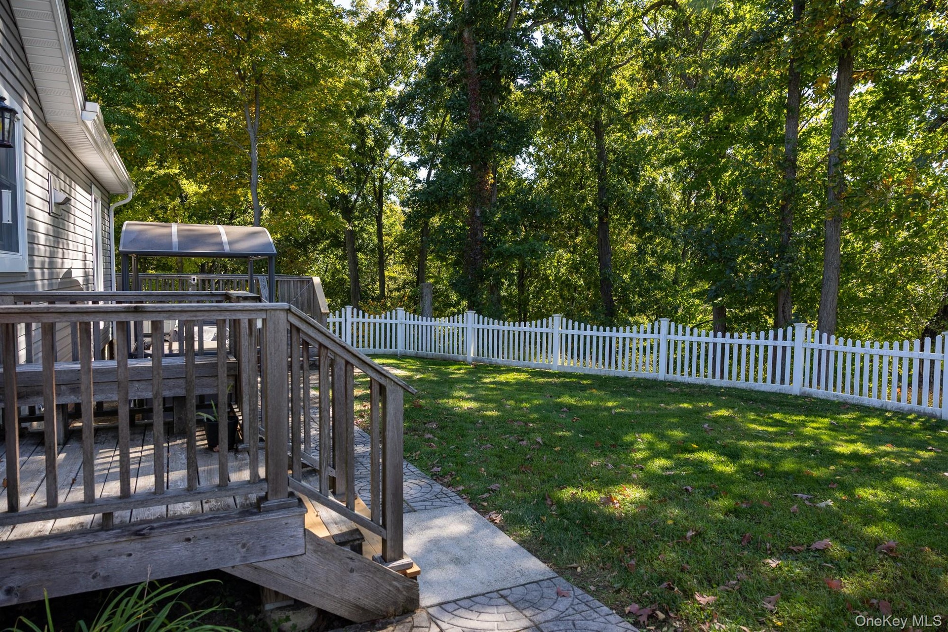 View of wood deck railings overlooking the fenced lawn.