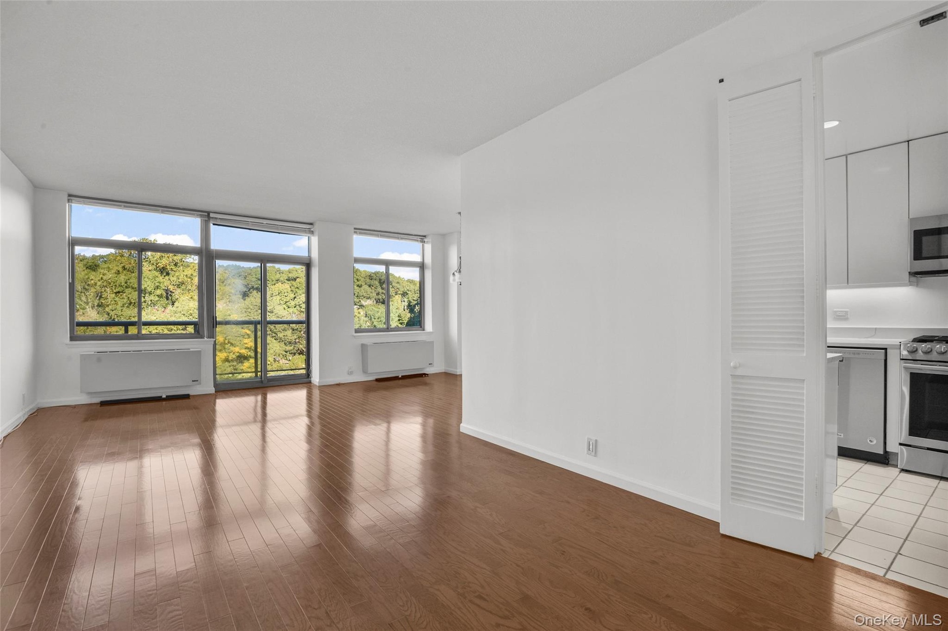 Living Room with Door to Terrace and Tree Top/Sky line View with Beautiful Hardwood Floors