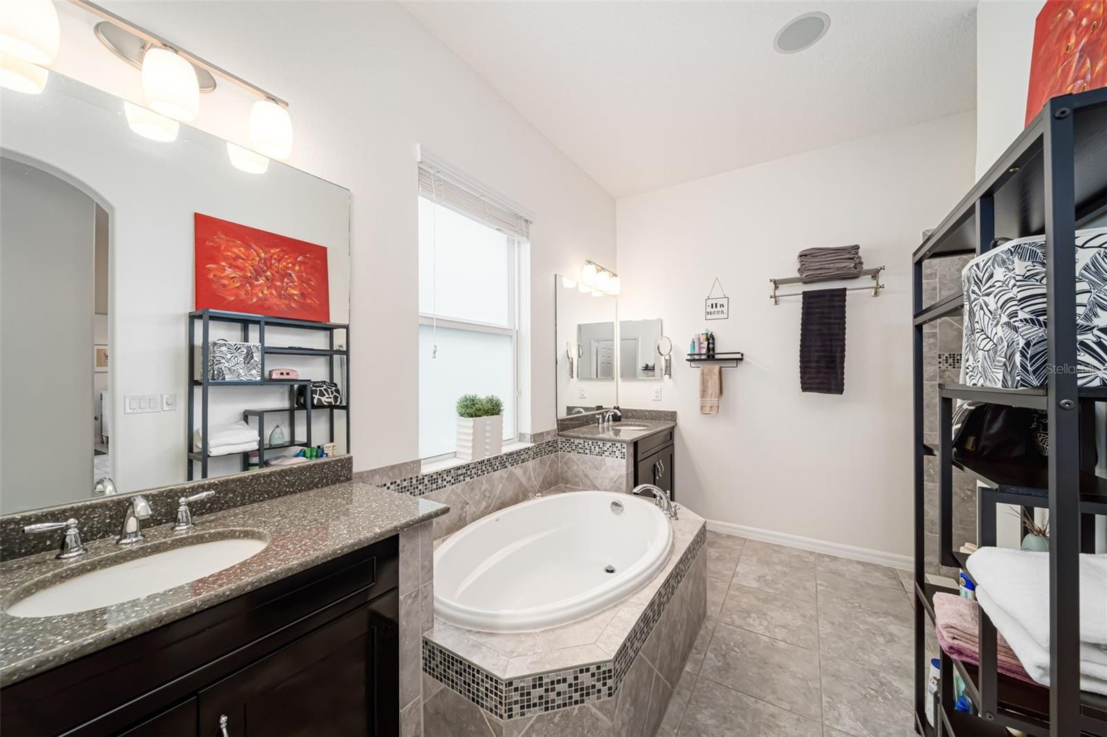 Spacious primary bath with a walk-in shower, dual vanities, and a relaxing soaking tub.