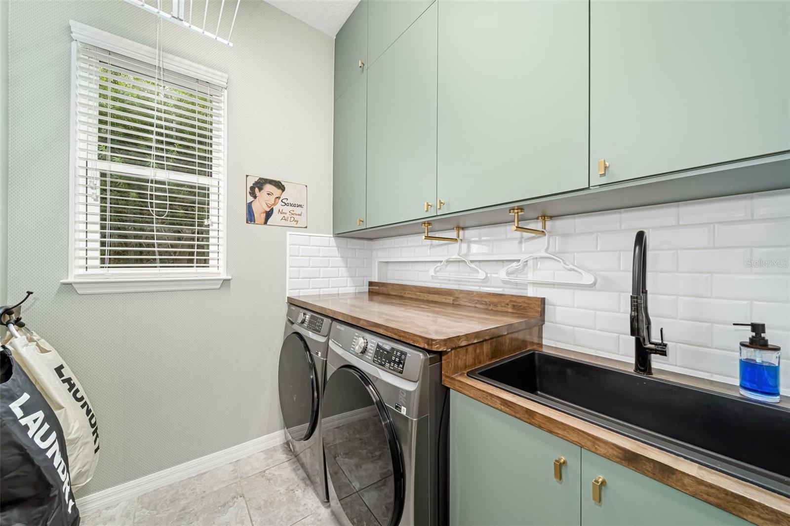 Thoughtfully designed laundry room with a utility sink and custom folding racks.