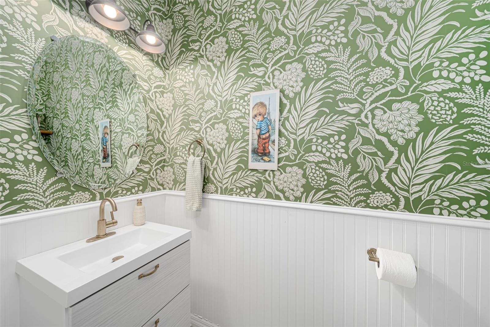Guest bathroom enhanced by stylish wallpaper and a touch of personality.