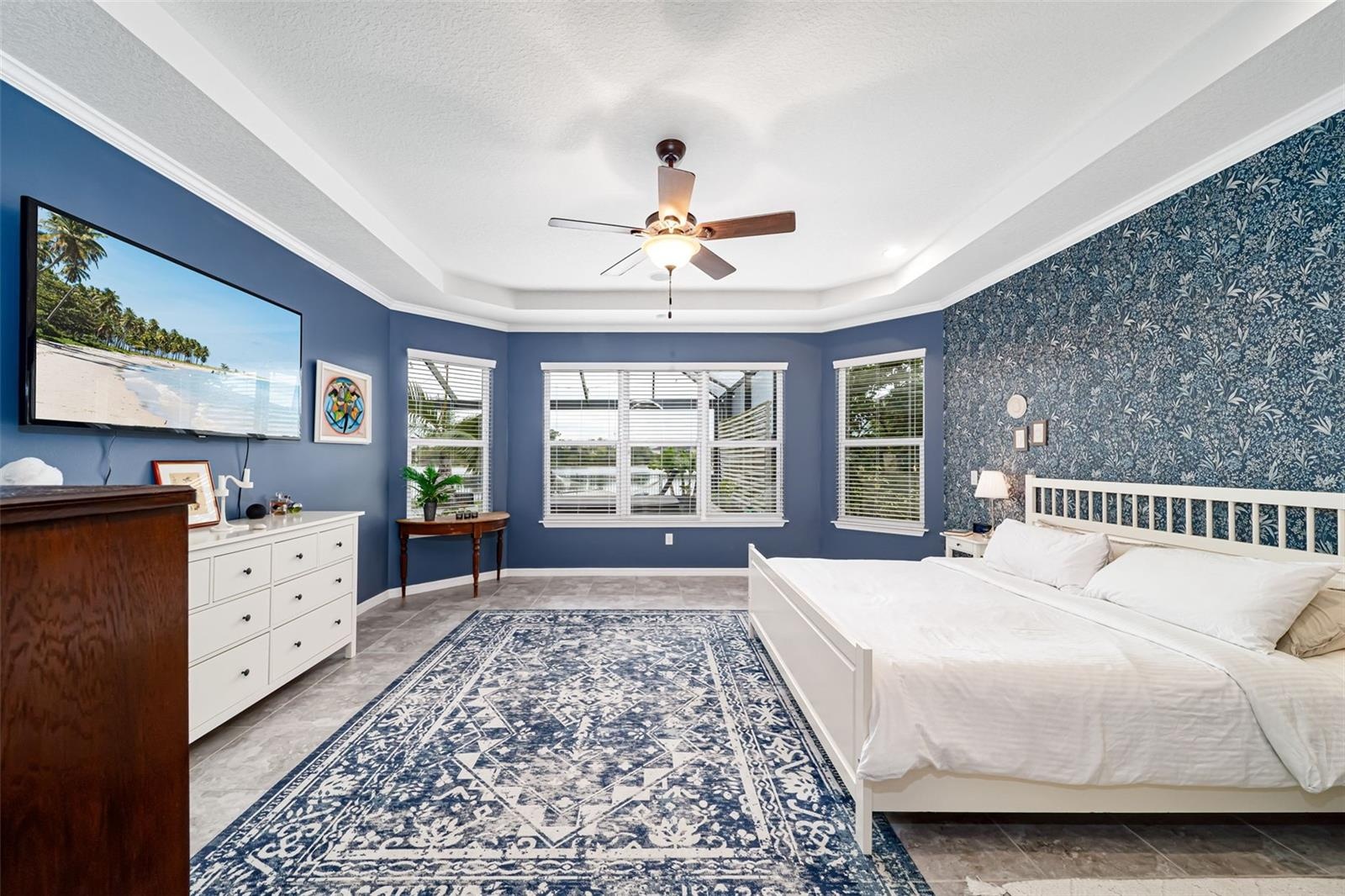 Primary bedroom with beautiful views and elegant designer wallpaper.