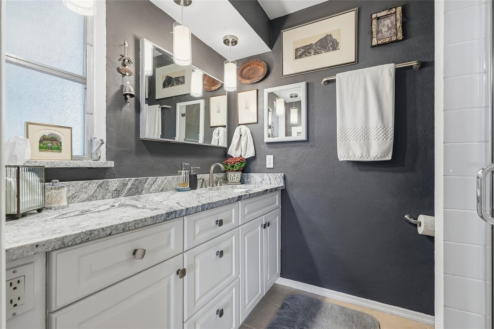 Start your day with generous vanity space, plentiful drawer storage, and pendant lighting that adds a stylish touch to the primary bath.