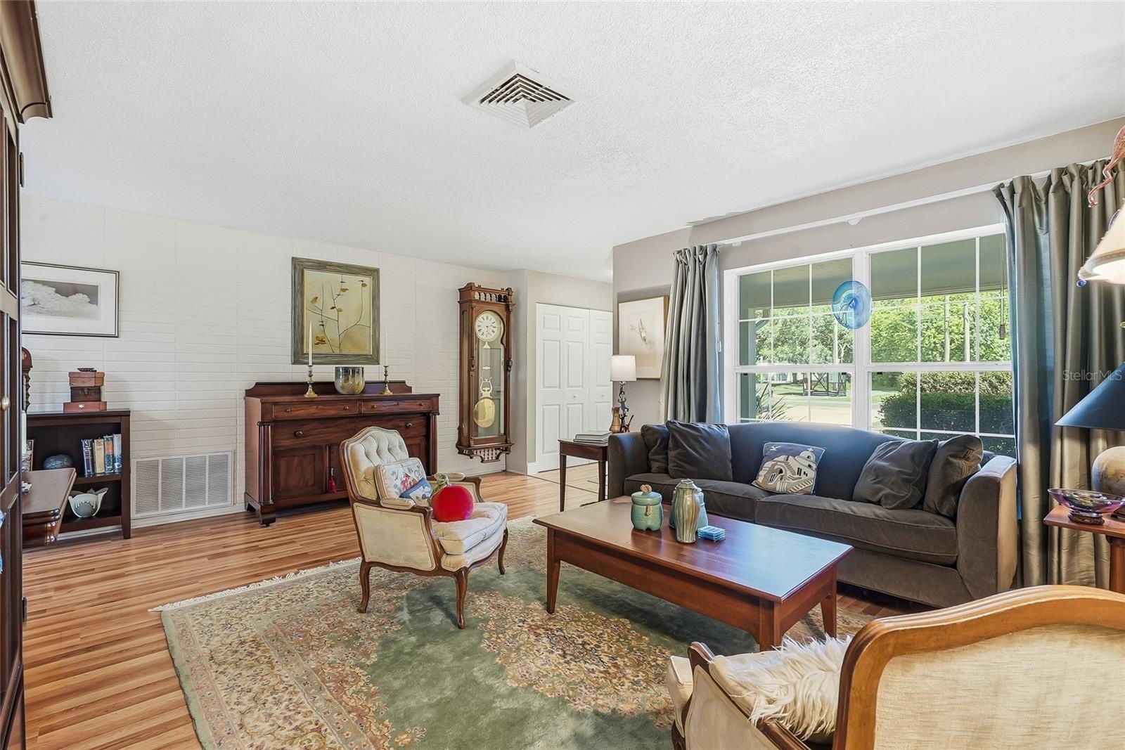 A generous front window frames leafy views and fills this welcoming gathering space with natural light.
