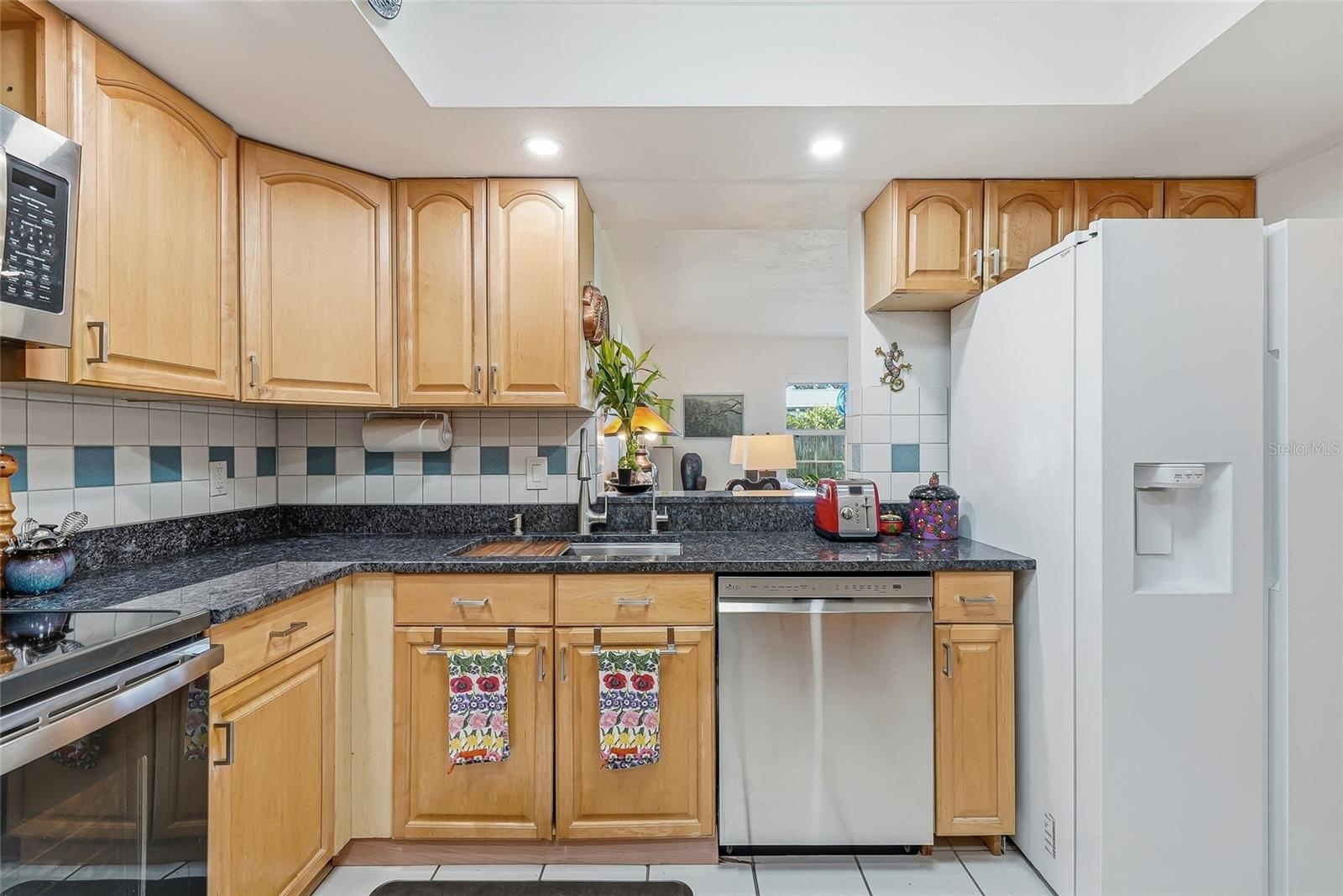 Everything within reach, with wraparound counters, plentiful cabinet storage, and a convenient pass-through connecting the kitchen to the family room.