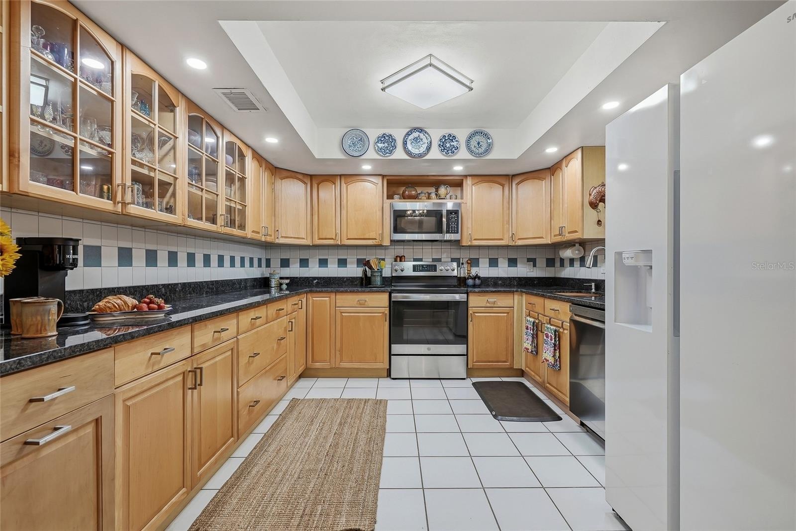 Spread out and create in a kitchen featuring generous counter space, abundant cabinetry, and glass-front cabinets to showcase your favorite pieces.