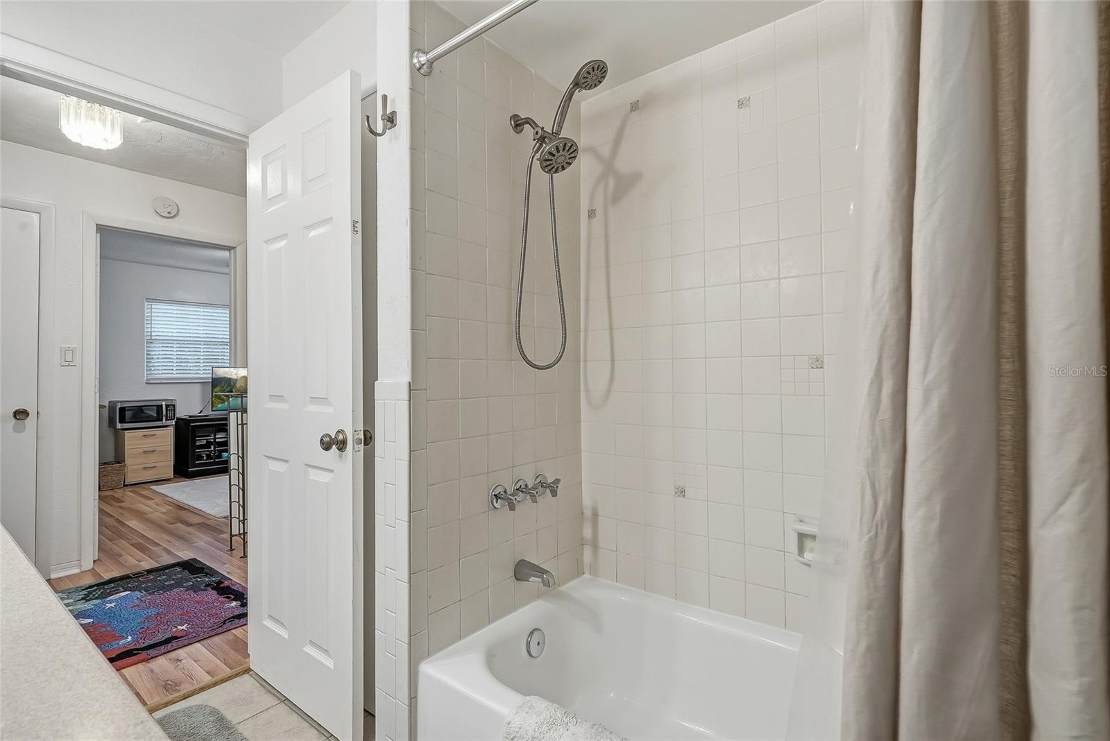 Enjoy the flexibility of a full tub and shower combination, finished with classic white tile and a handheld showerhead.