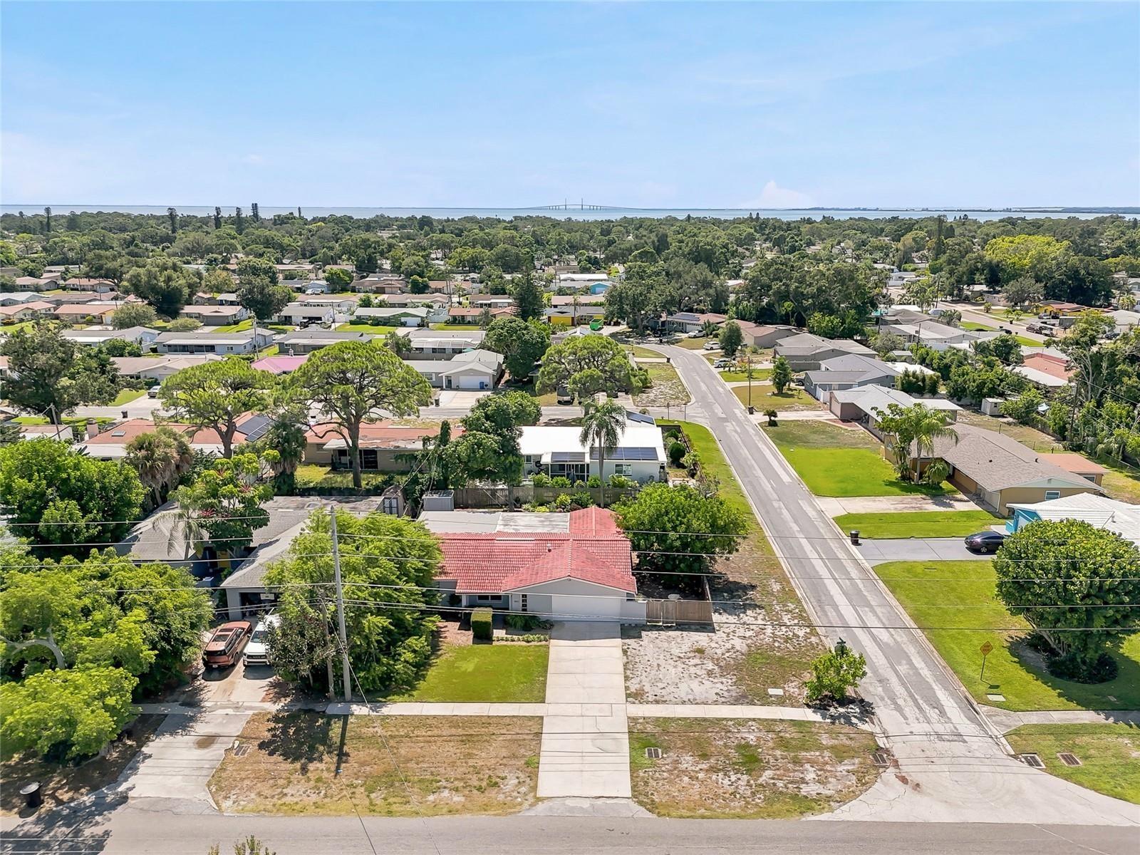 See the corner setting from above, with a broad driveway, mature trees, and generous outdoor space surrounding the home.