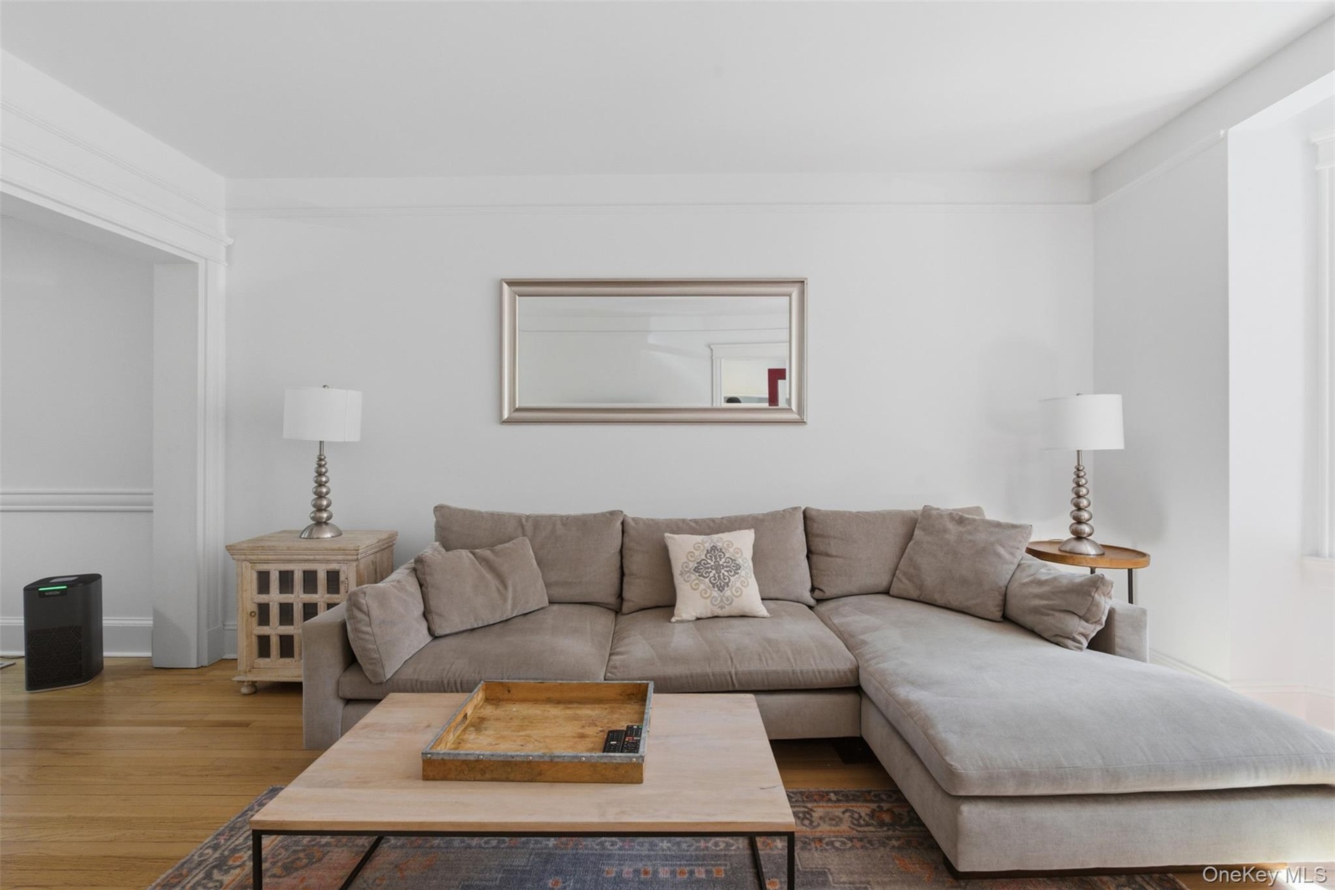 Hardwood flooring, crown molding, and a wide doorway