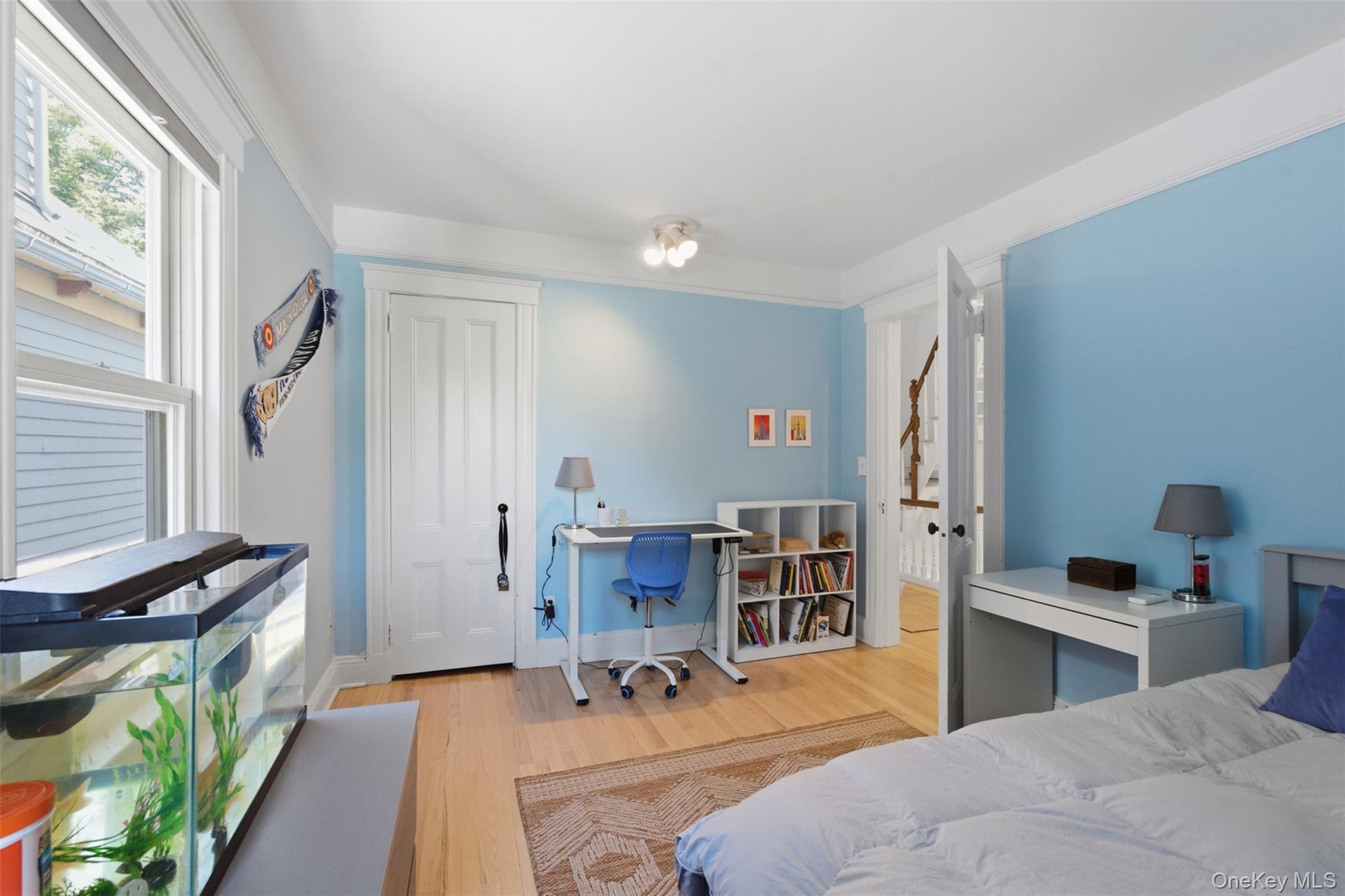 Wood-finish flooring, white trim, recessed lighting, and a paneled door