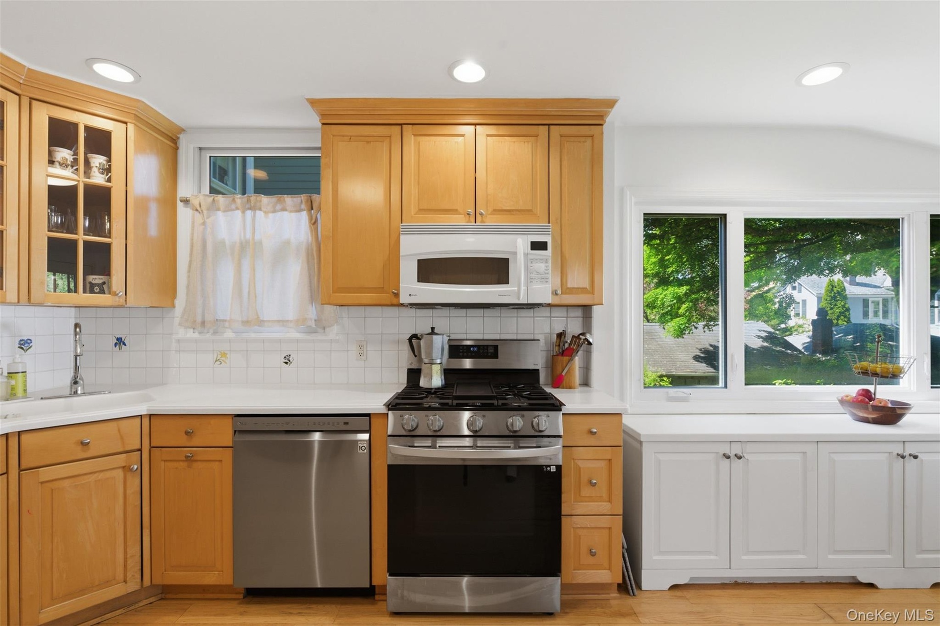 Kitchen featuring wood-finish cabinetry, white countertops, a stainless steel gas range, a built-in microwave, and recessed lighting
