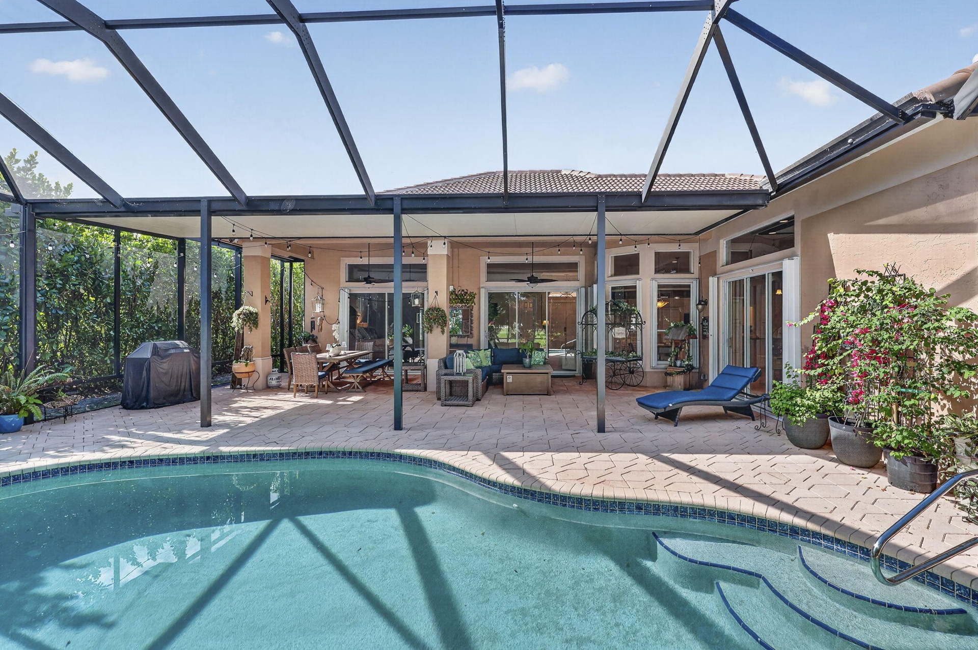 Screened lanai featuring a swimming pool, paved patio, and covered seating area