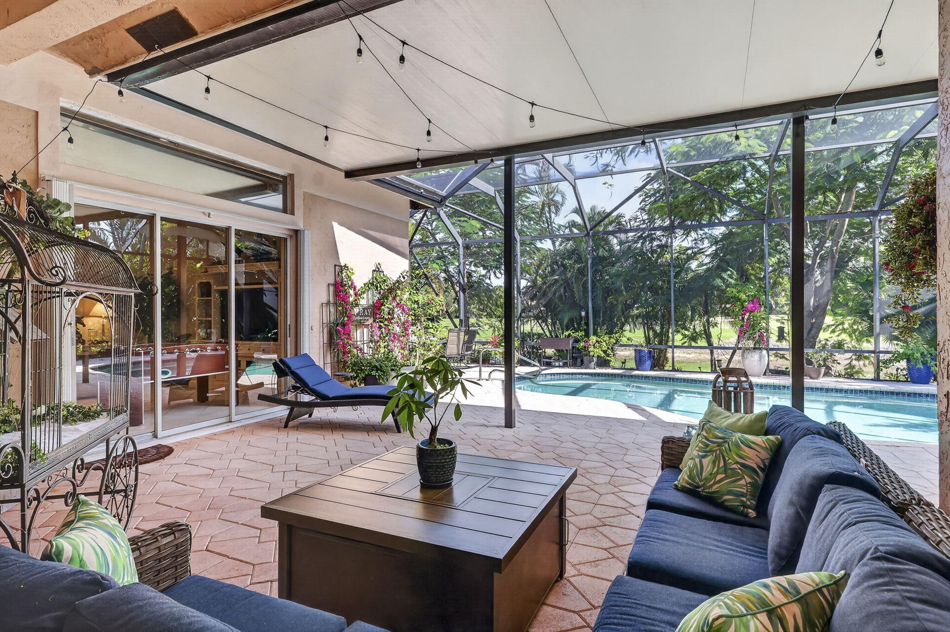 Screened patio featuring a swimming pool, red brick-finish flooring, and sliding glass doors