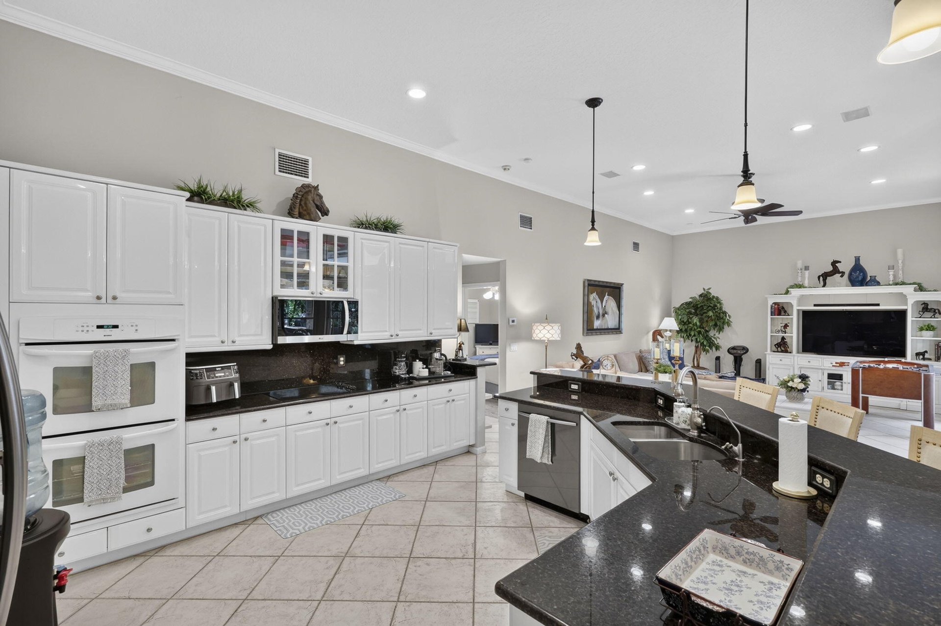 Kitchen featuring white cabinetry, dark stone countertops, stainless steel appliances, and tile flooring