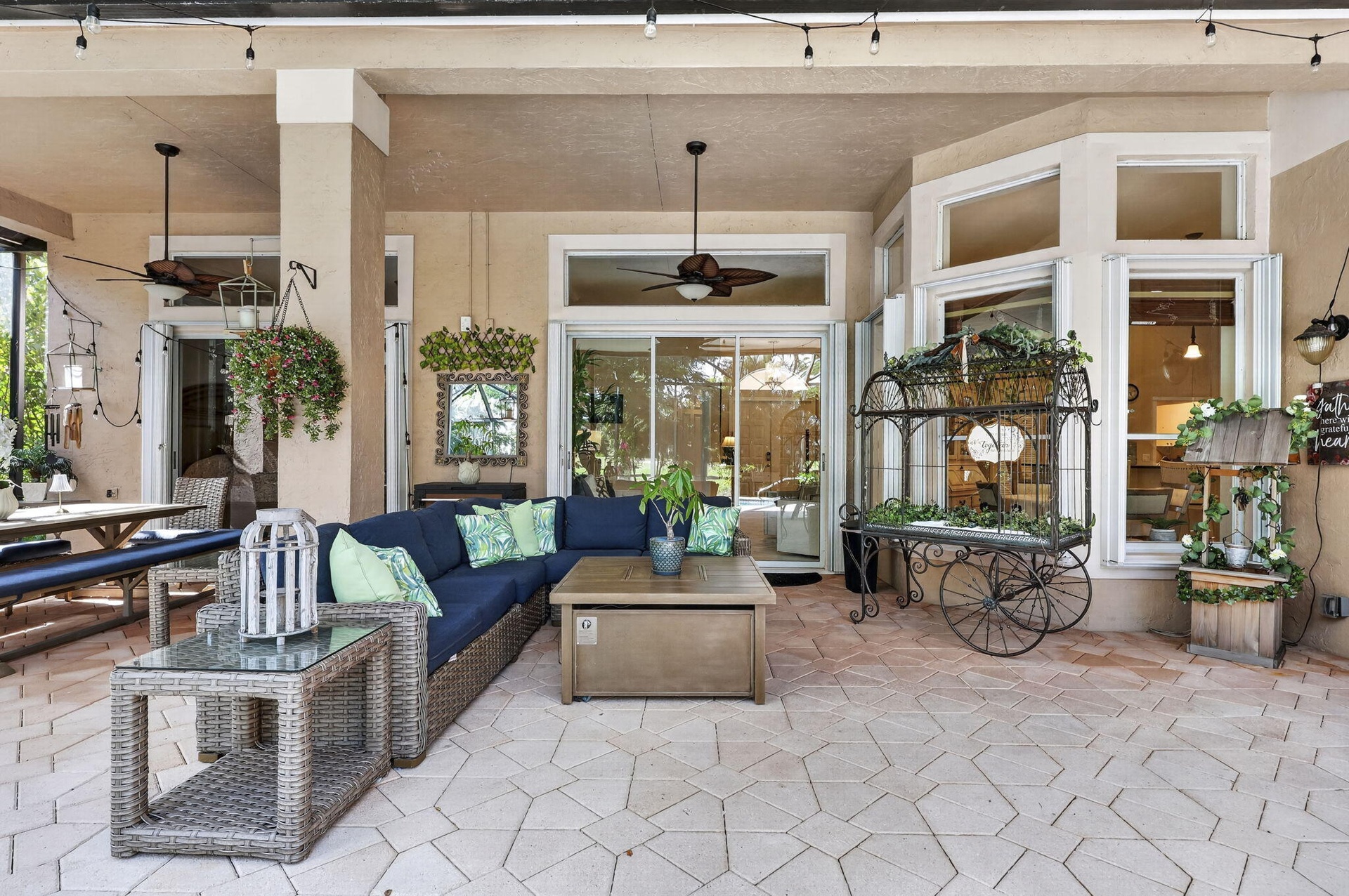 Expansive covered patio featuring a paver surface, ceiling fans, and multiple sliding glass doors