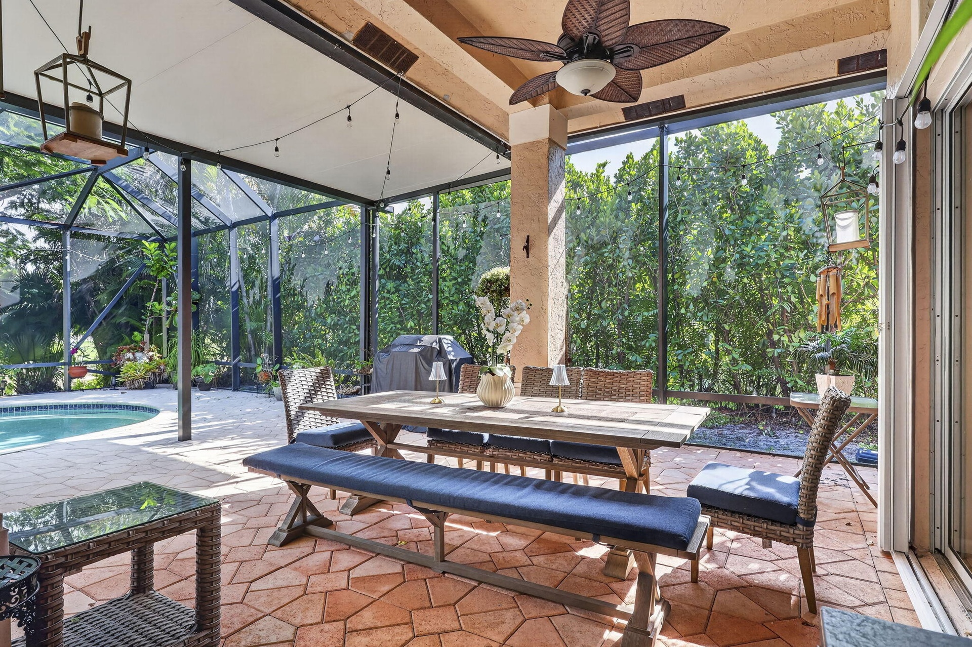 Screened outdoor patio featuring a ceiling fan, a dining area, and a swimming pool