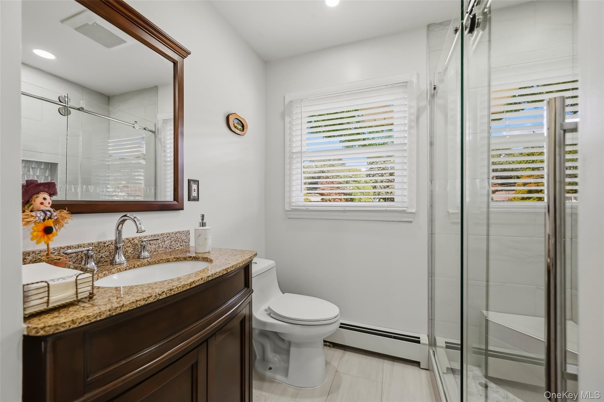 Dark wood-finish vanity with a granite countertop, undermount sink, and chrome faucet