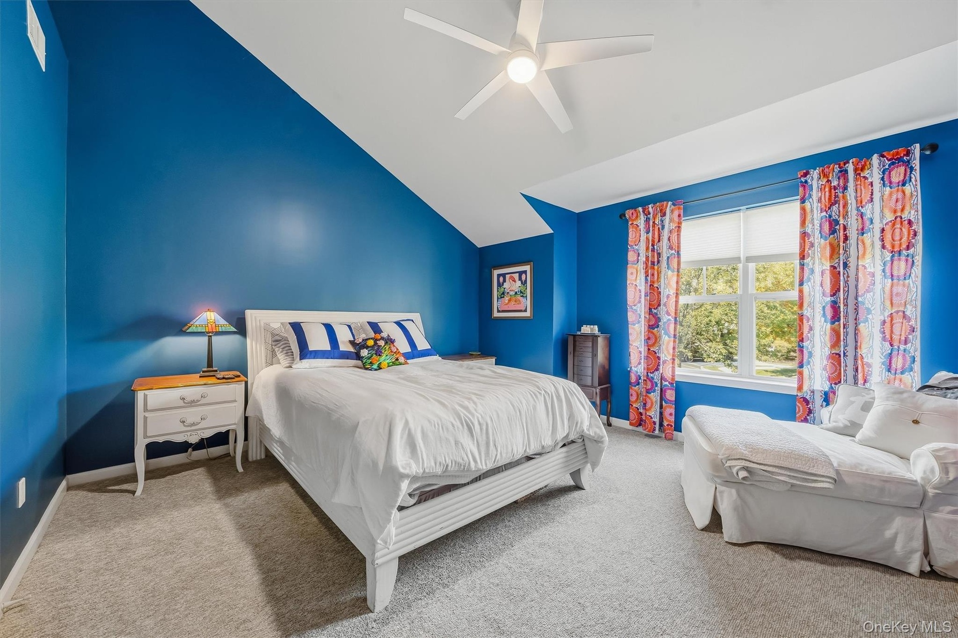 The guest bedroom has a  high angled ceiling witih a walk in closet and new carpet.