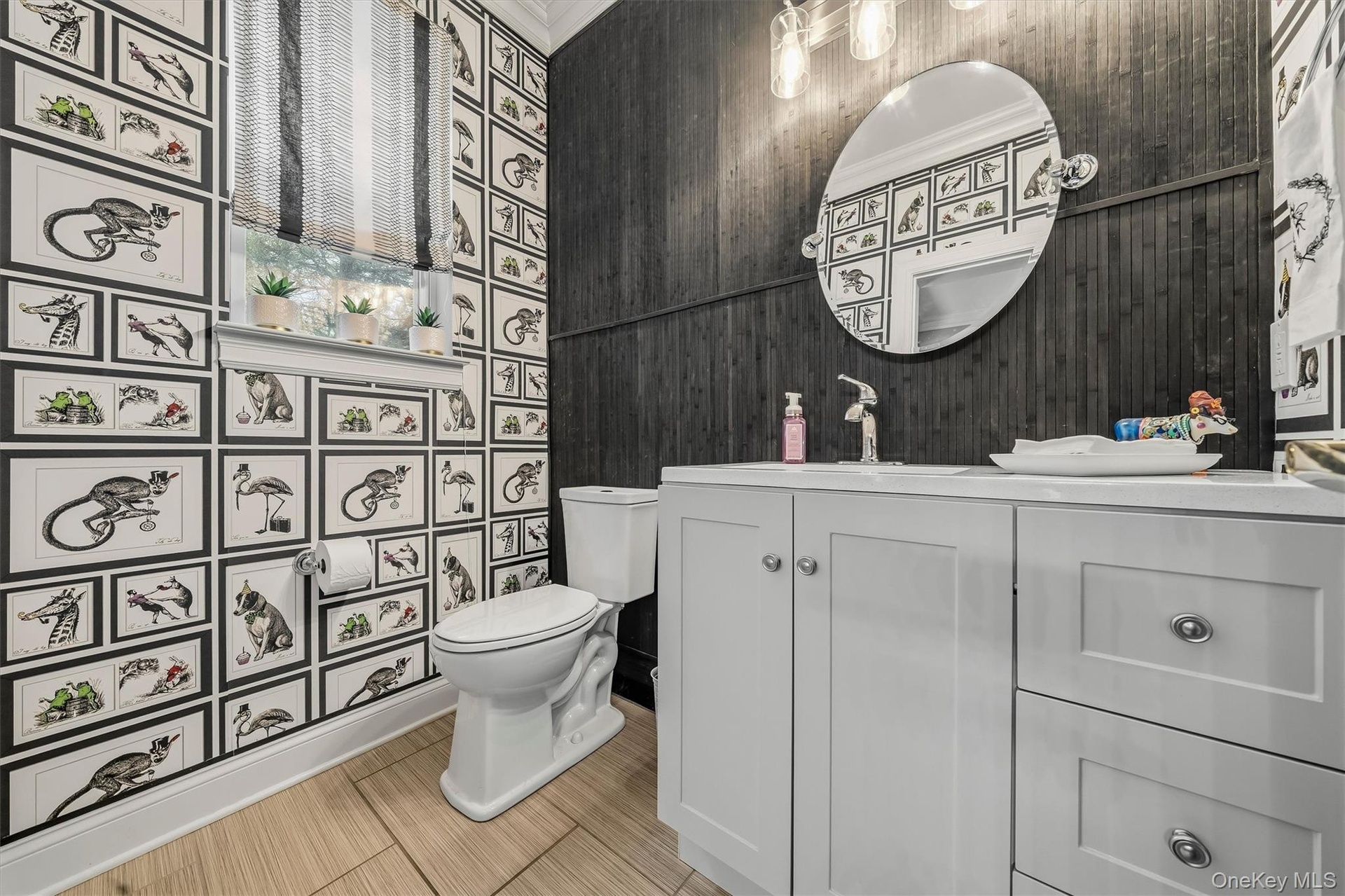 The main floor oversized half bath with designer wall treatments.