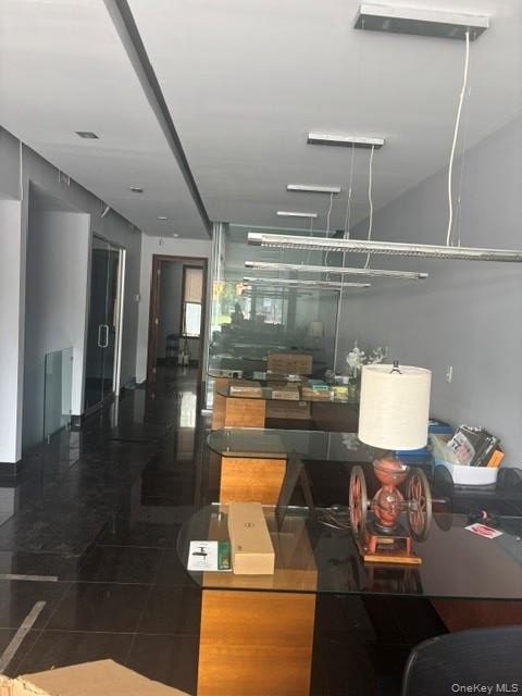 Recessed lighting, linear pendant lighting, dark tile flooring, and glass partition walls