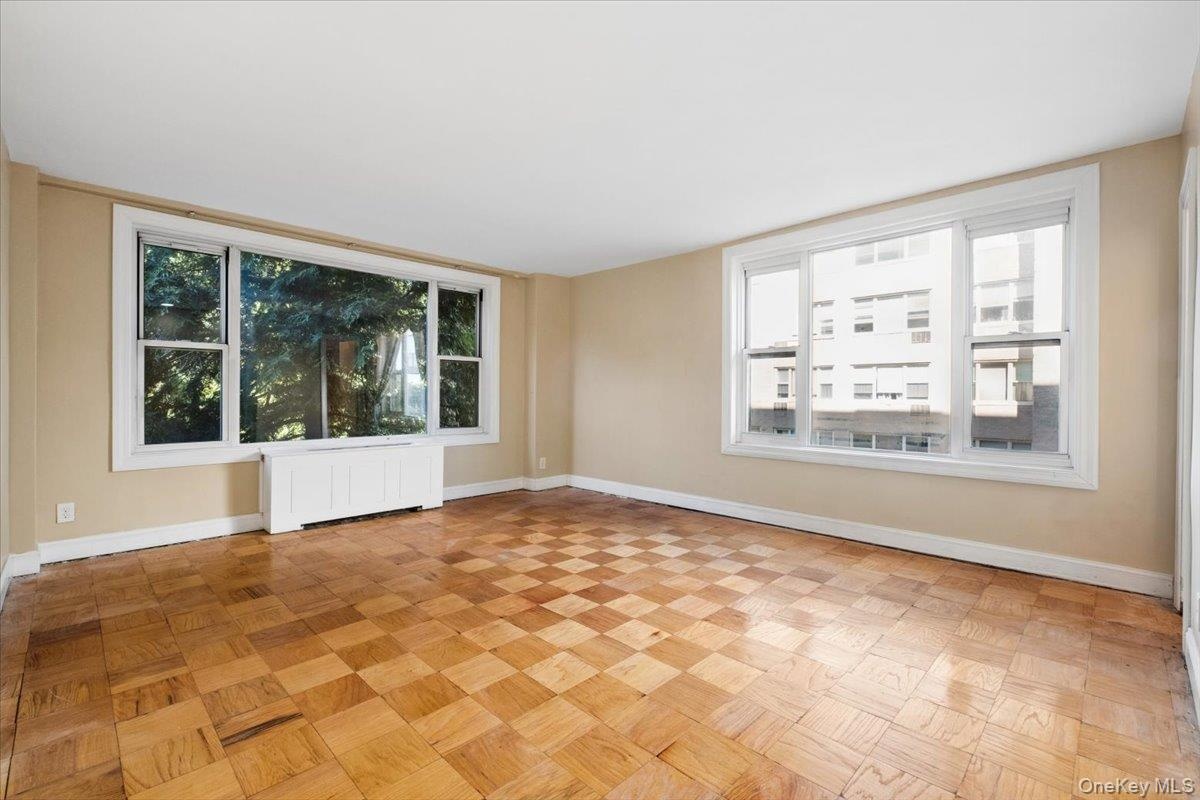 Spacious primary bedroom with large windows and ensuite bathroom.