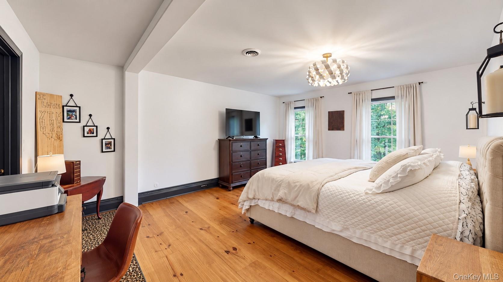 Hardwood flooring, recessed lighting, and a decorative ceiling fixture