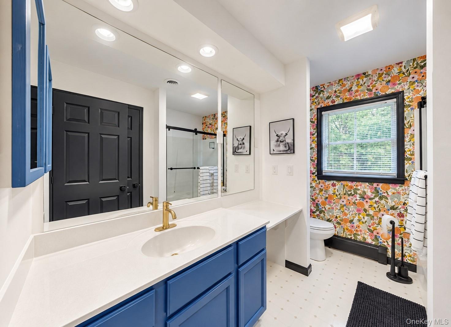 Elongated vanity with a single basin, quartz countertop, and gold-finish faucet
